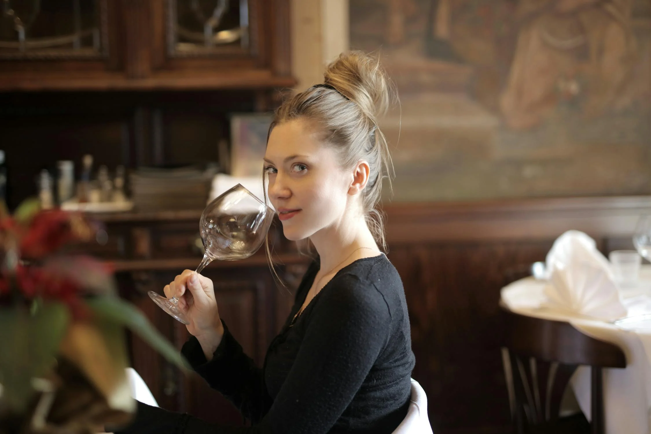 Une femme souriante regardant de son côté dans un restaurant | Source : Pexels