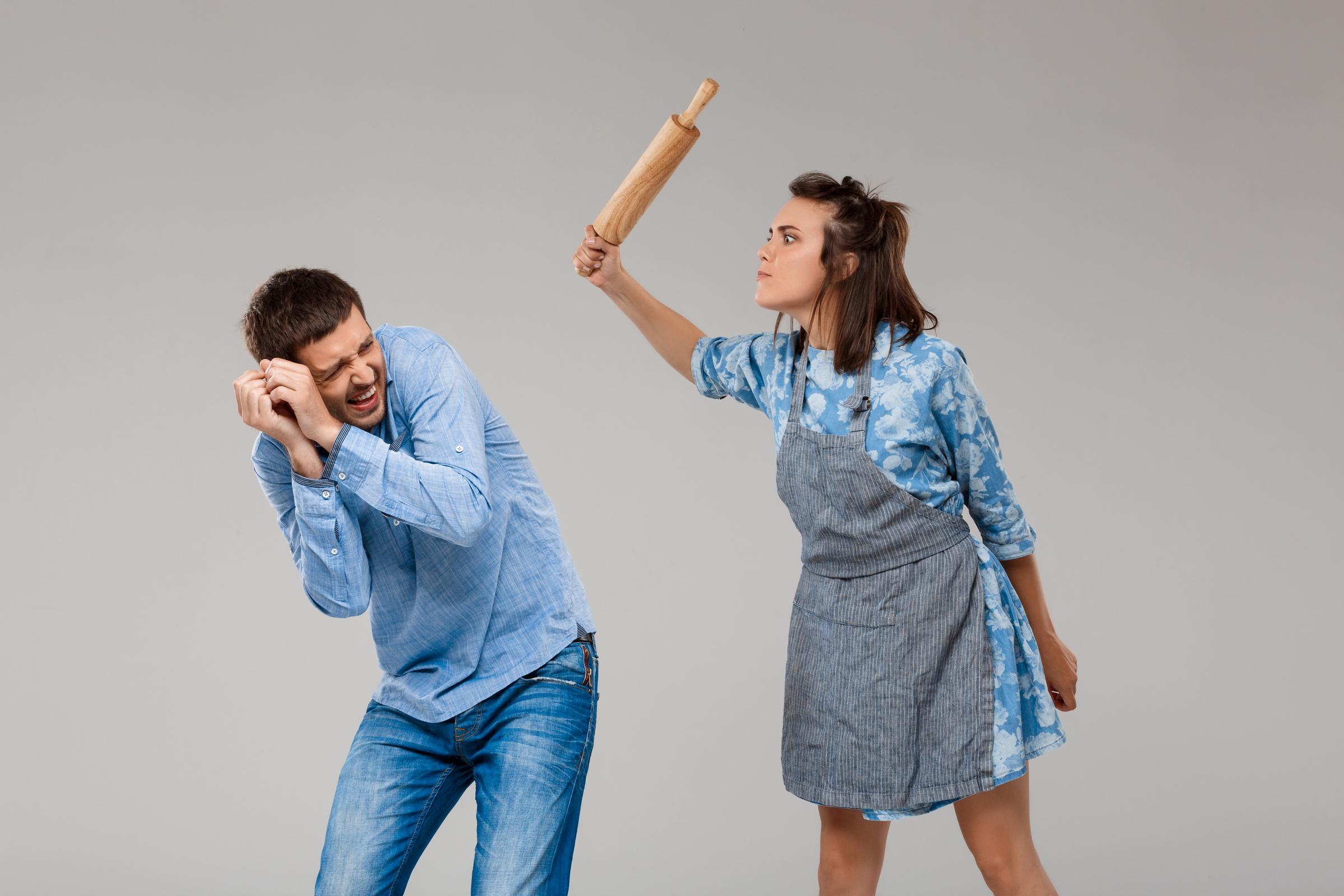 Une femme menaçant un homme recroquevillé | Source : Freepik