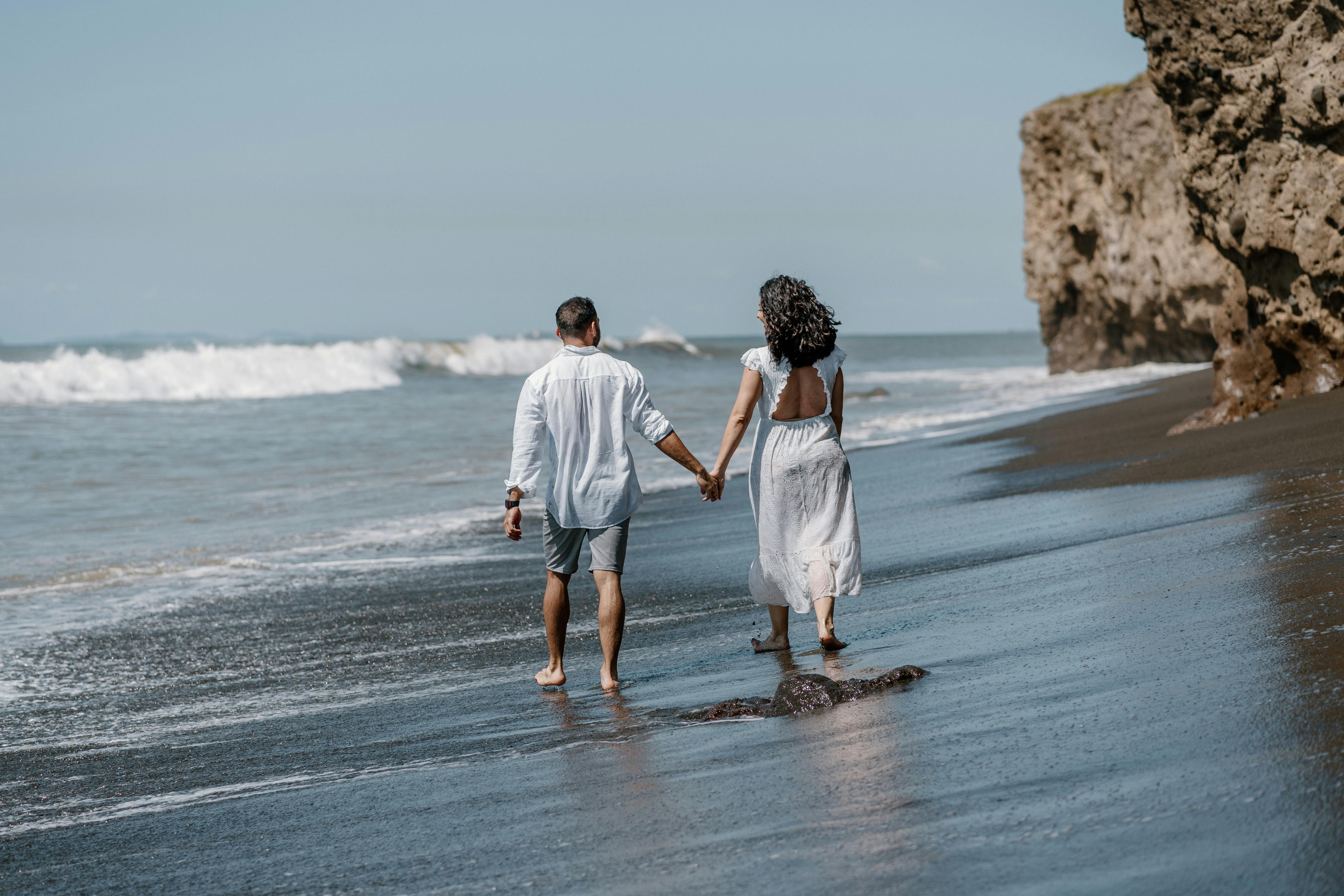 Un couple se tenant par la main sur la plage | Source : Pexels