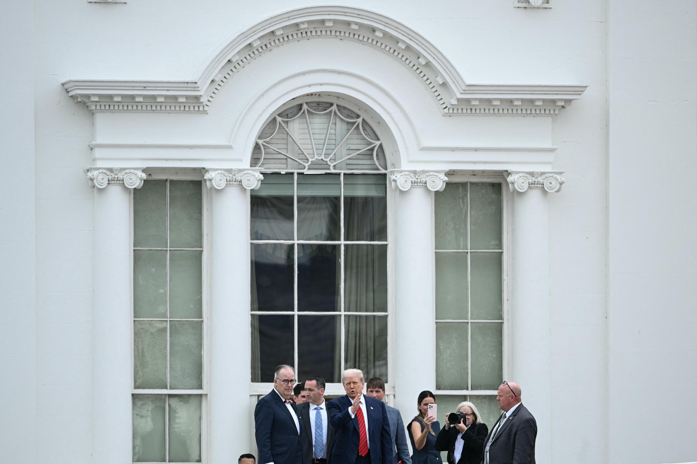 Debout aux côtés de ses collaborateurs sur le toit de l'aile ouest de la Maison Blanche, le président Donald Trump semblait engagé dans une discussion animée lors de sa visite inattendue sur le toit.