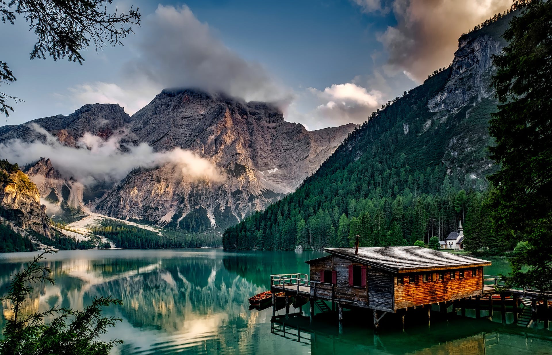 Une maison en bois au milieu d'un lac surplombant les montagnes | Source : Pexels