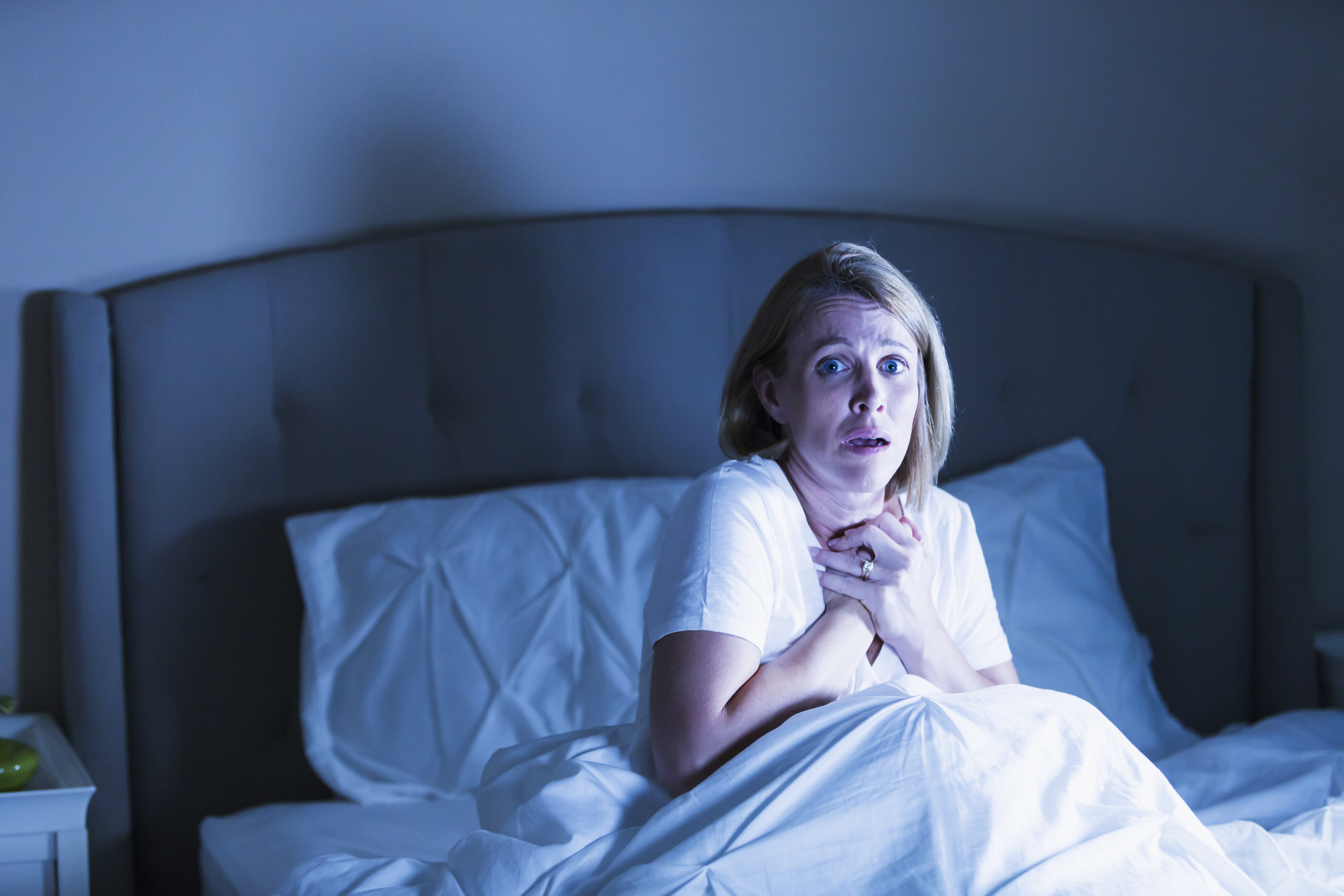 Femme au lit réveillée par quelque chose d'effrayant | Source : Getty Images