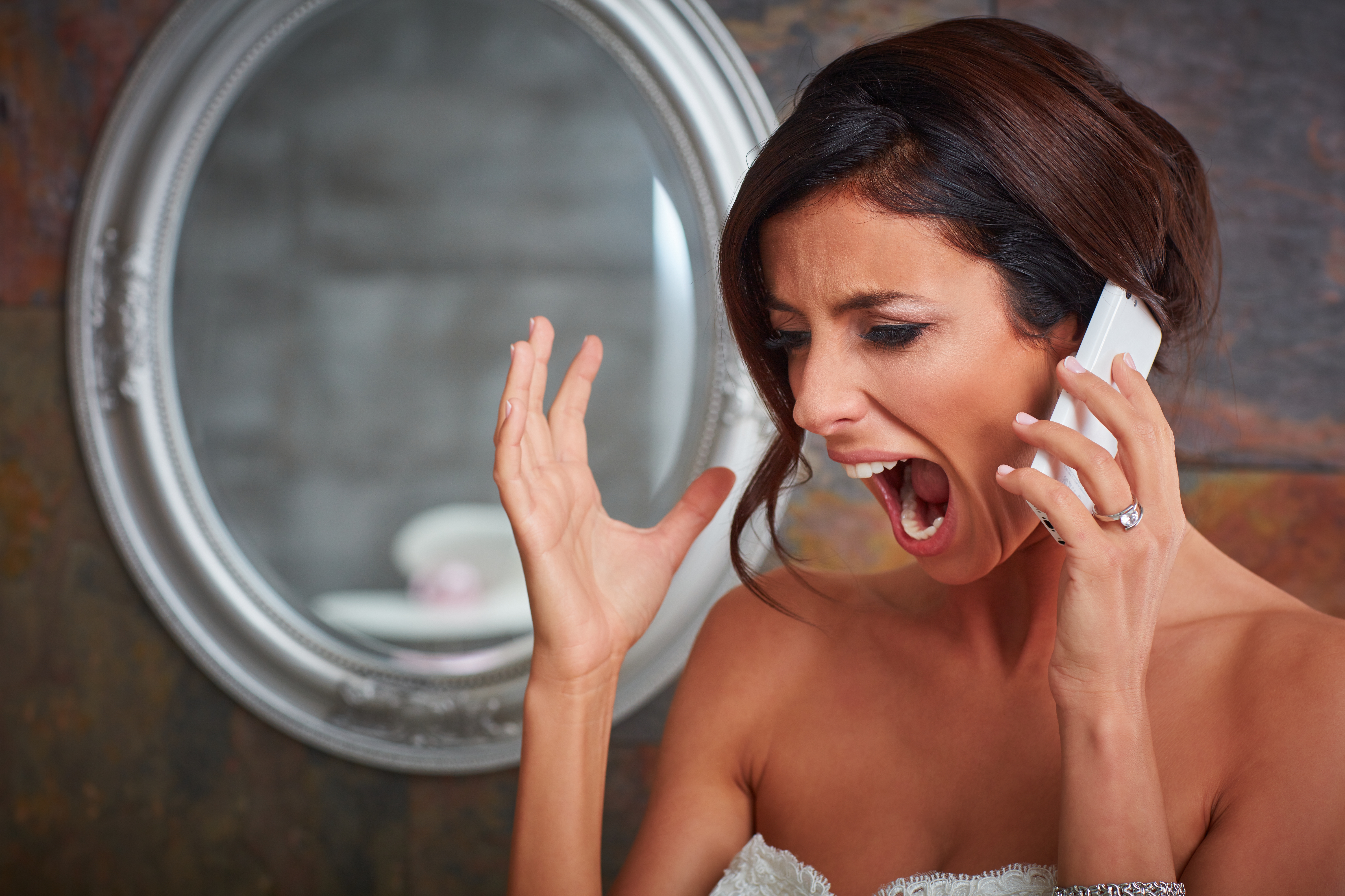 Une mariée qui crie tout en parlant au téléphone | Source : Shutterstock