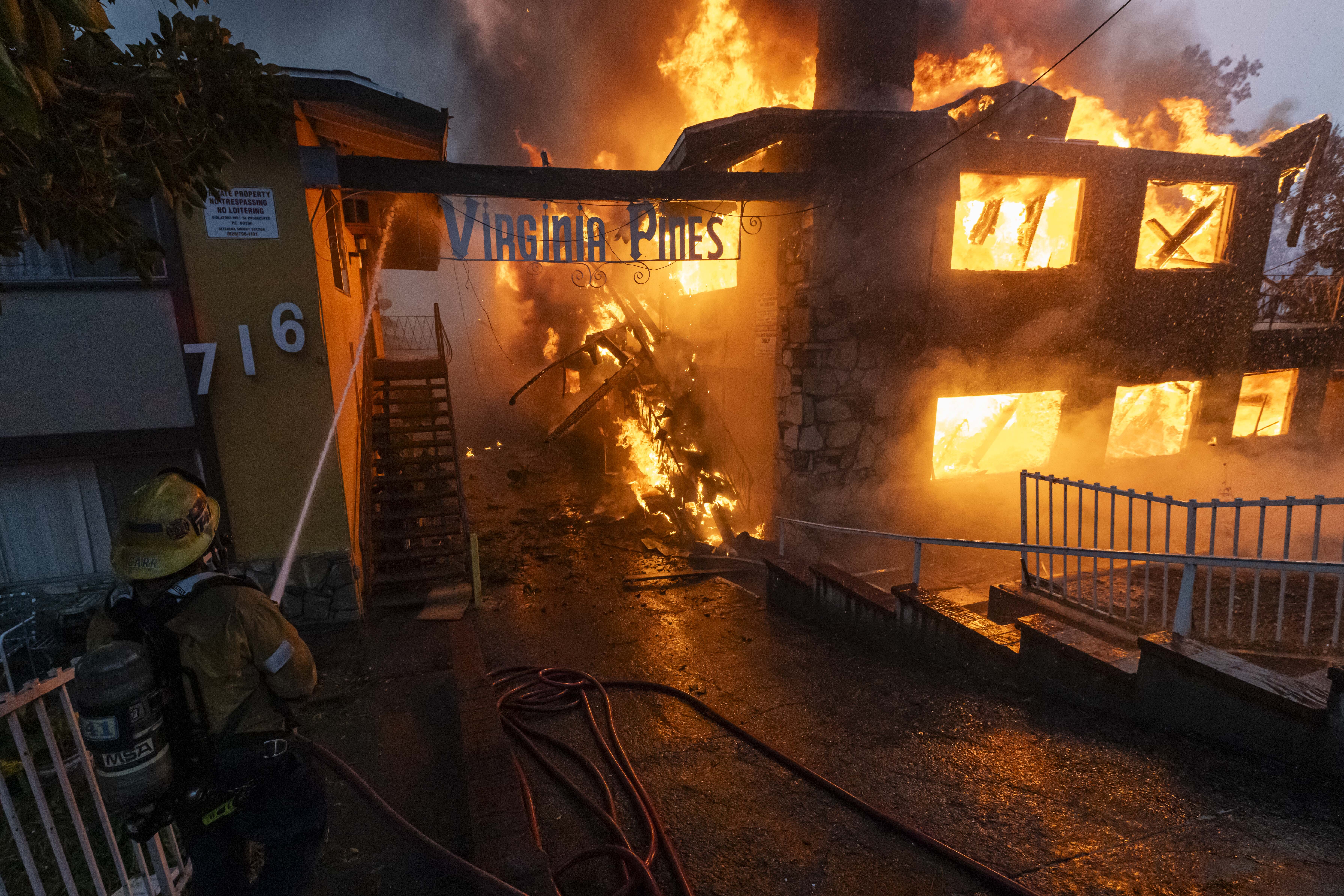 Un pompier du LAFD arrose un complexe d'appartements en feu de l'incendie Eaton à Altadena, en Californie, le 8 janvier 2025 | Source : Getty Images