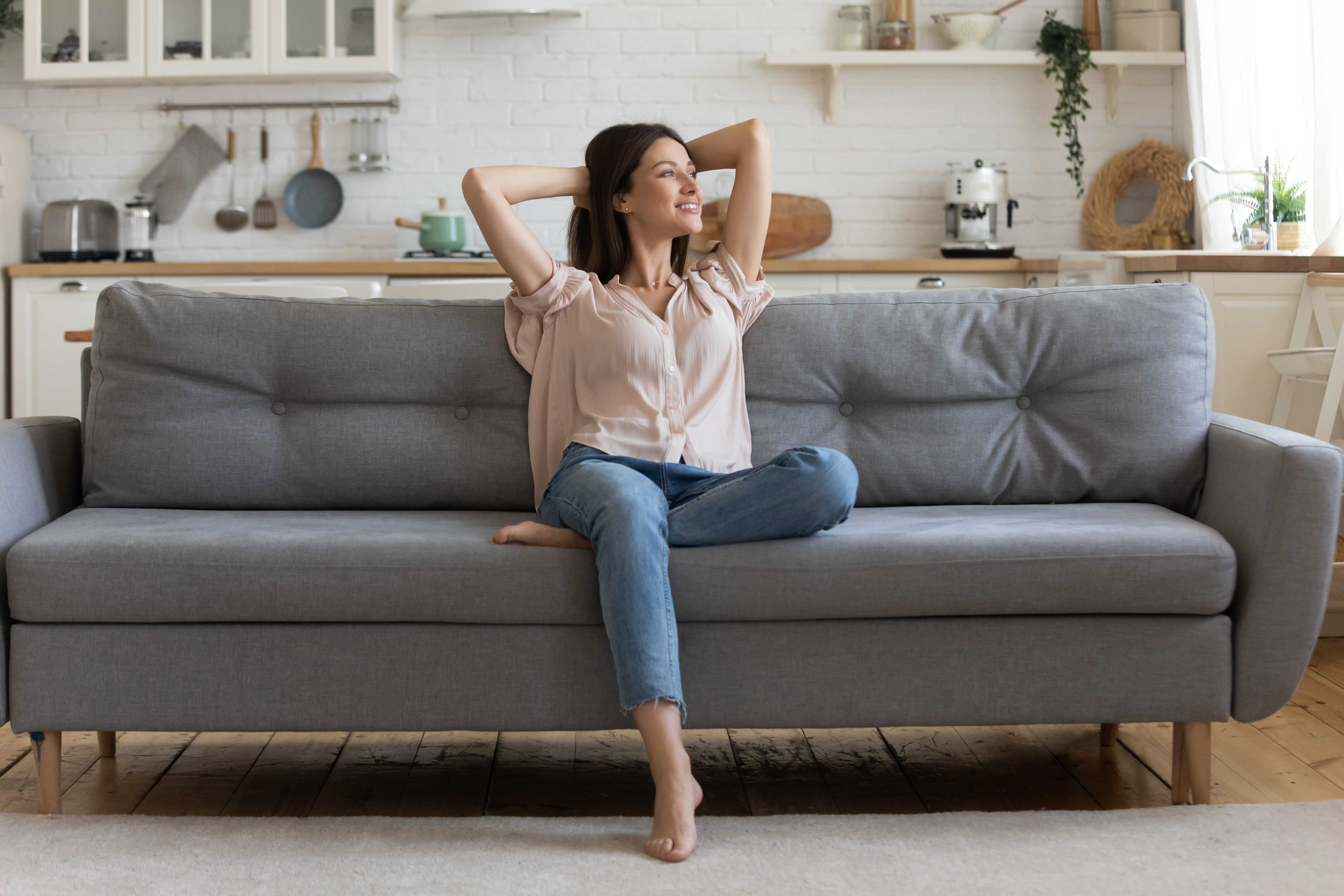 Femme heureuse sur un canapé | Source : Shutterstock