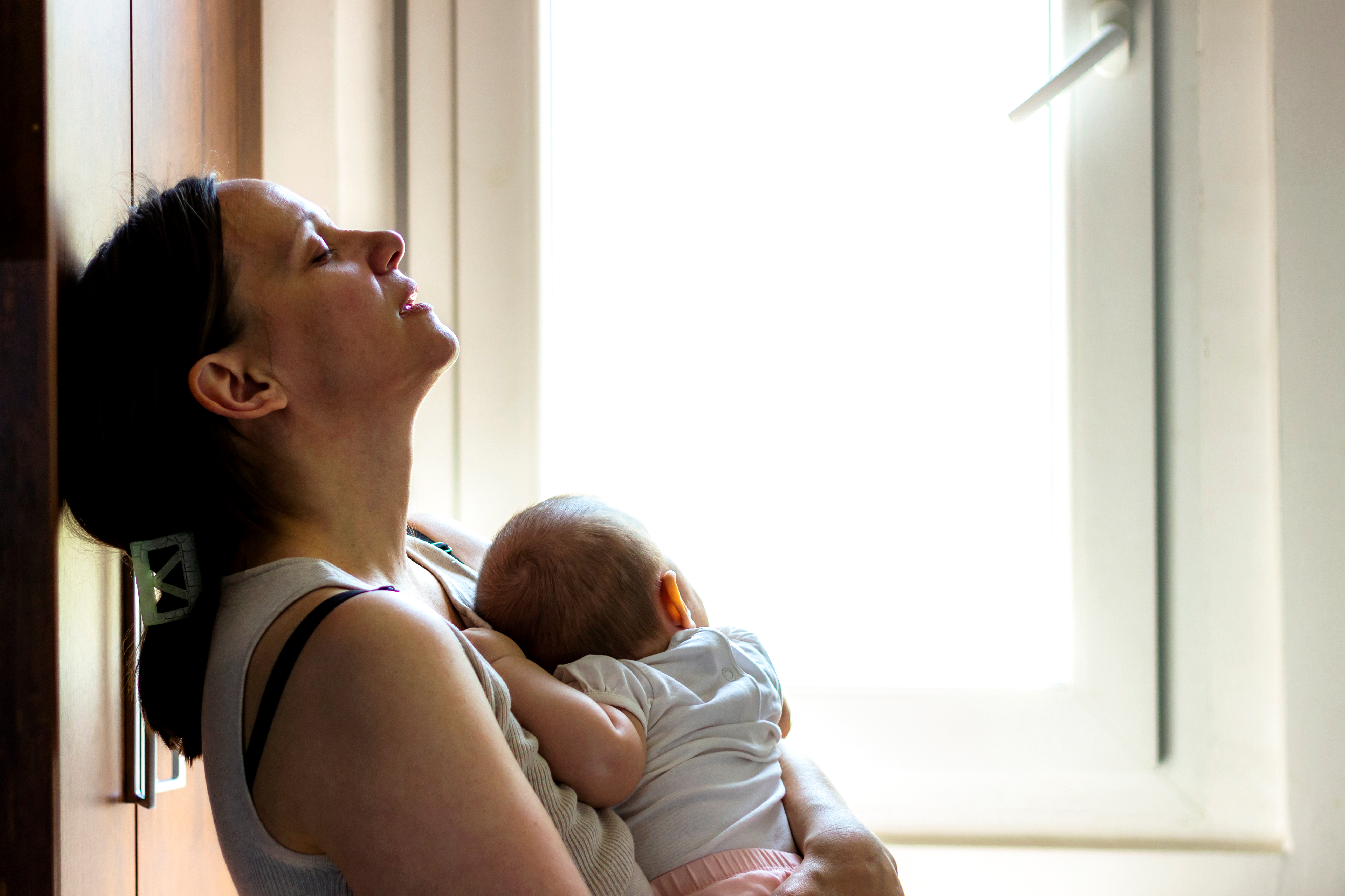 Une mère à l'air fatigué tout en tenant son bébé | Source : Shutterstock