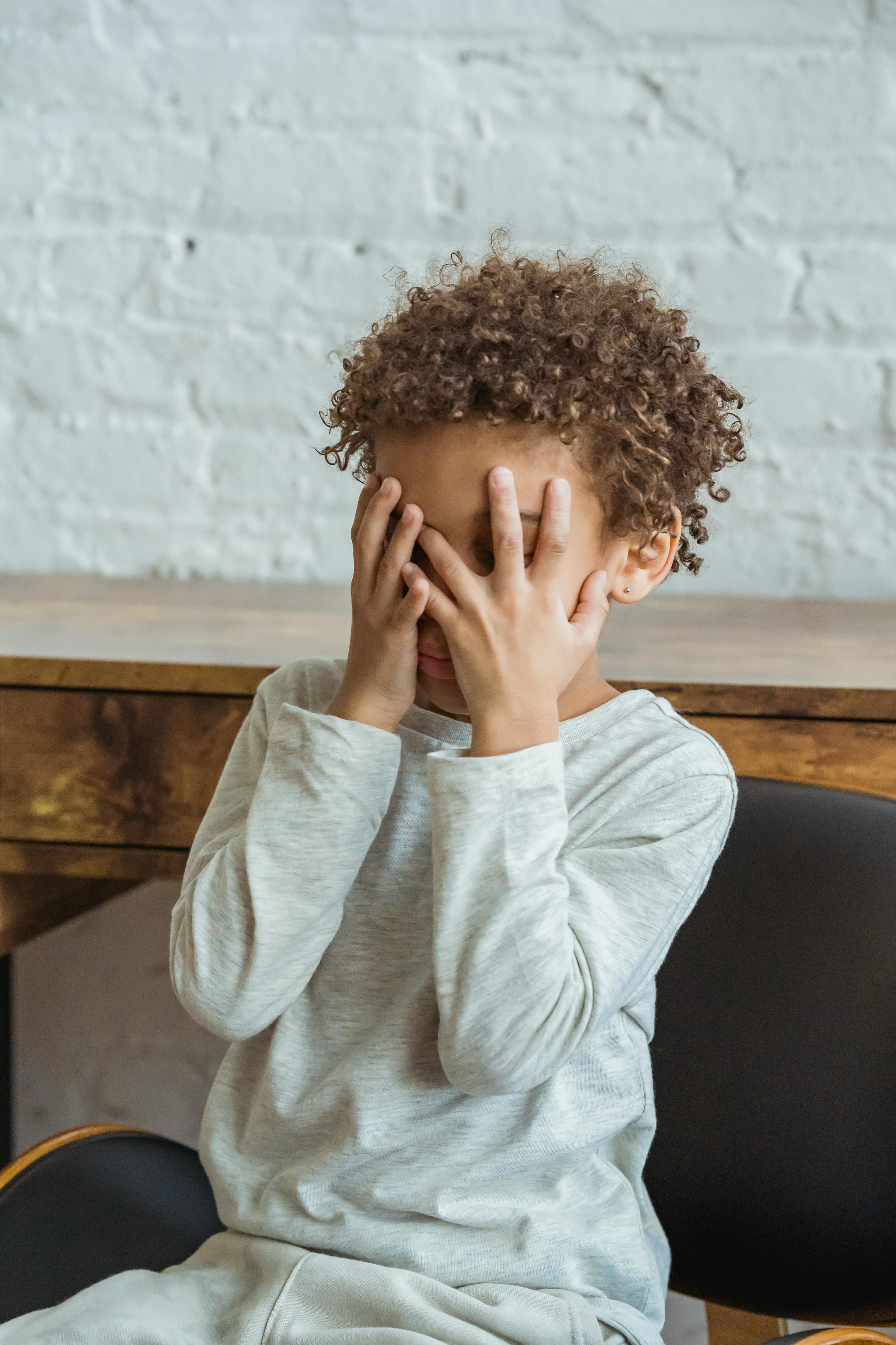 Un enfant se couvrant le visage avec ses paumes | Source : Pexels