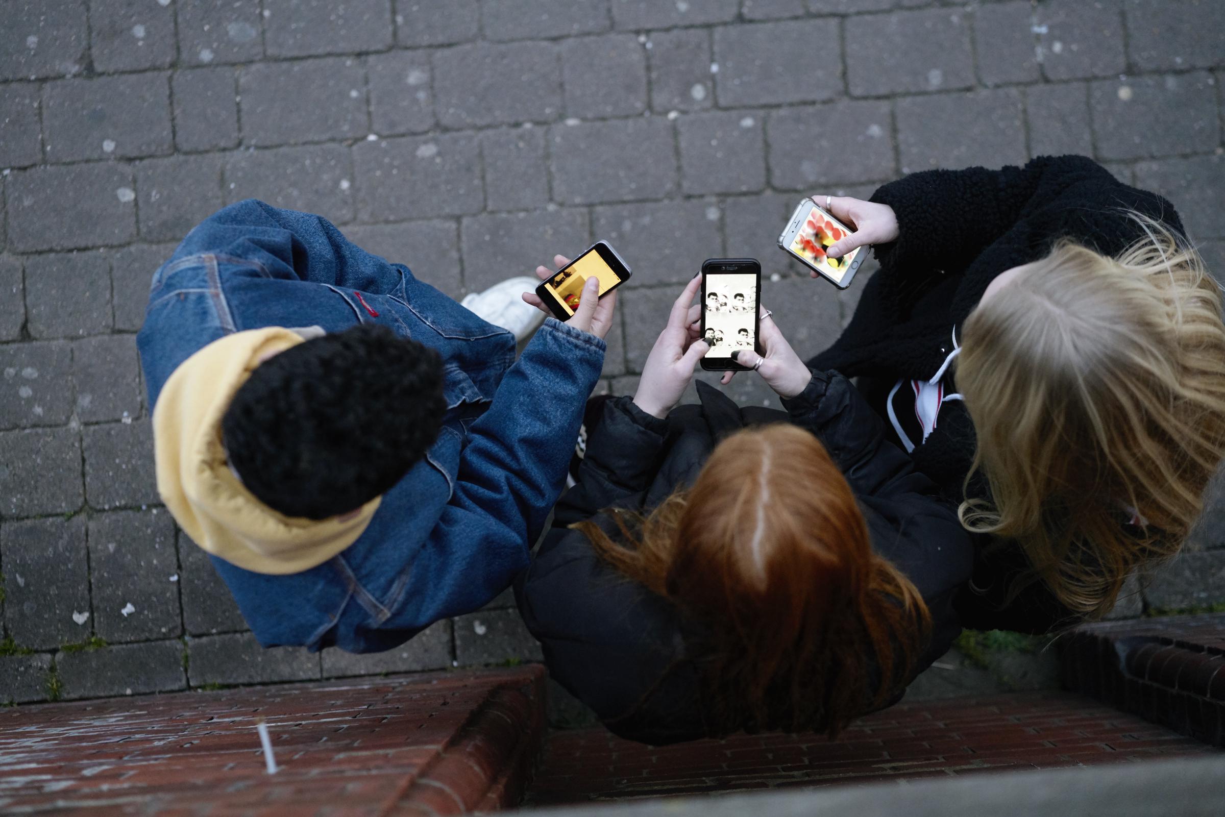 Un groupe d'amis sur leur téléphone | Source : Getty Images