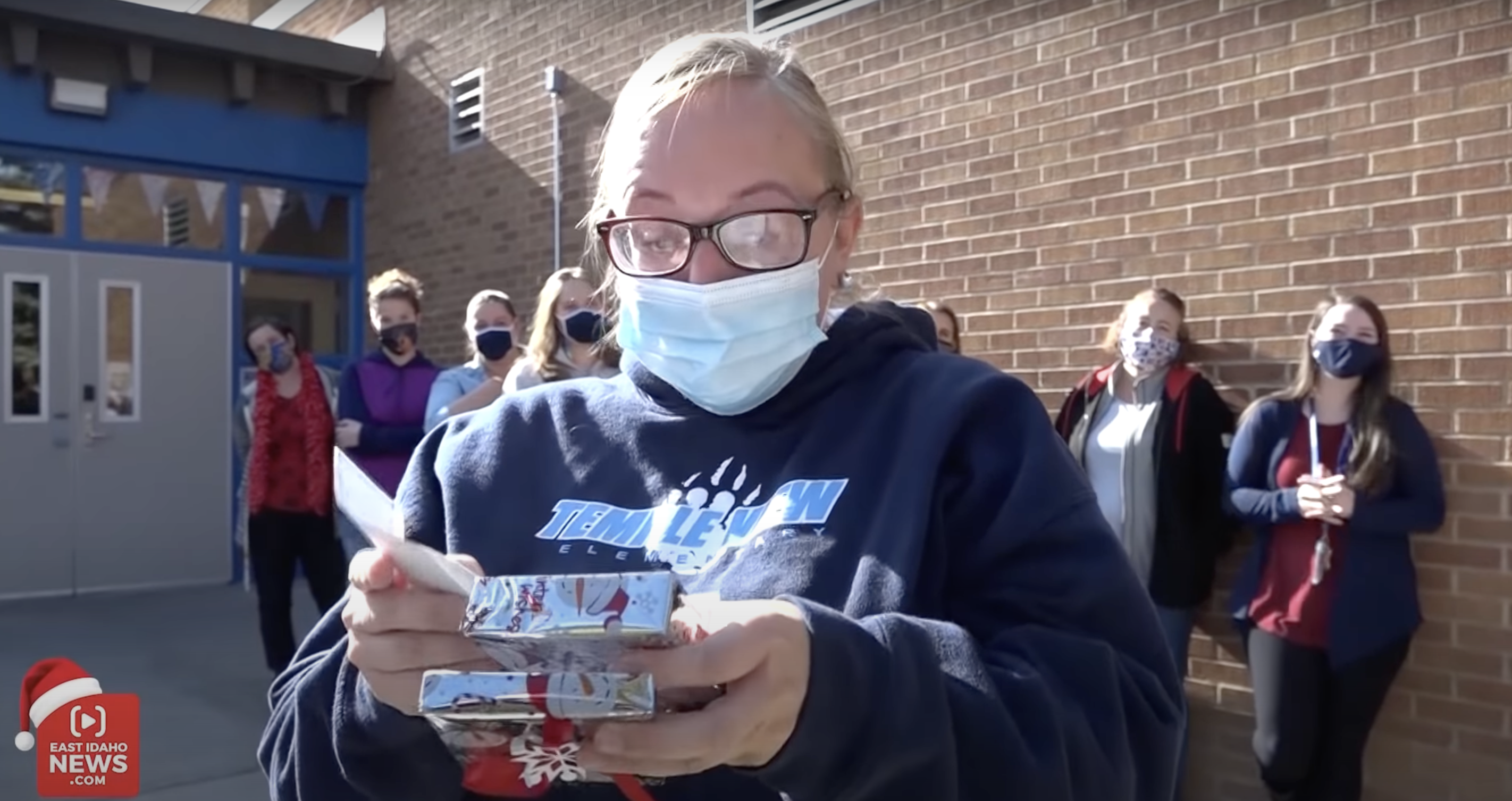 Darci Orchard est photographiée en train d'ouvrir le paquet cadeau du Père Noël secret. | Source : YouTube.com/East Idaho News