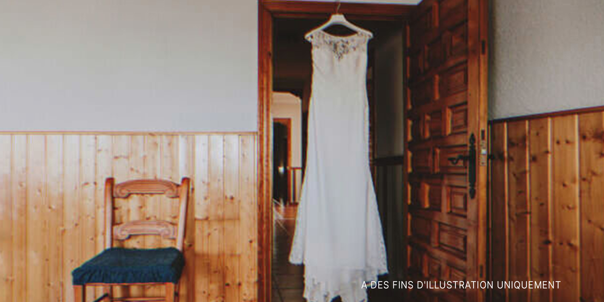 Robe de mariée suspendue dans l'embrasure d'une porte. | Source : Shutterstock