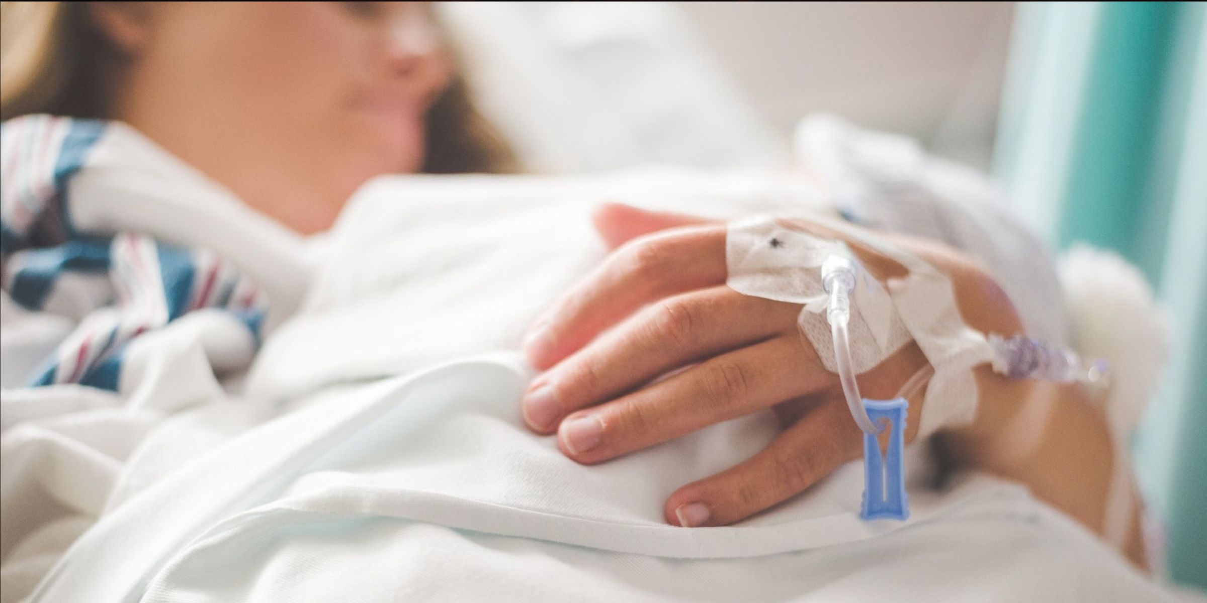 Gros plan sur le bras d'une patiente avec une perfusion intraveineuse dans un milieu hospitalier | Source : Pexels