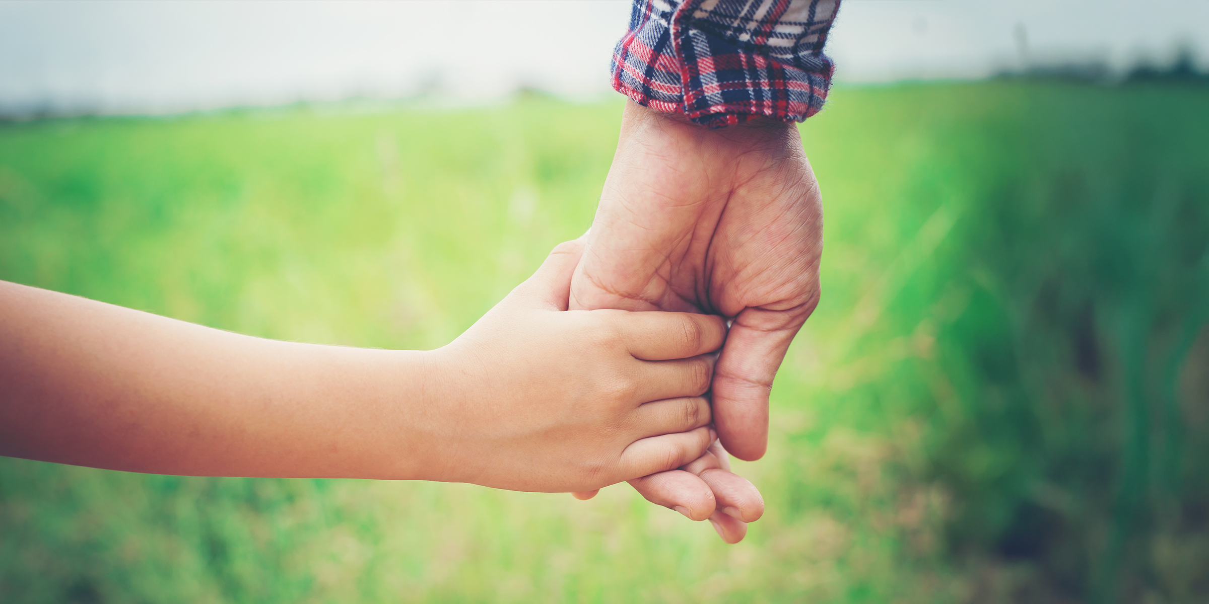 Un enfant tenant la main d'un homme | Source : Shutterstock