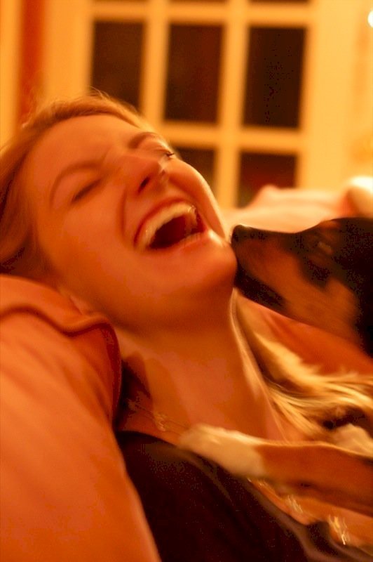 Une femme qui rit avec son chien. l Source: Wikimedia
