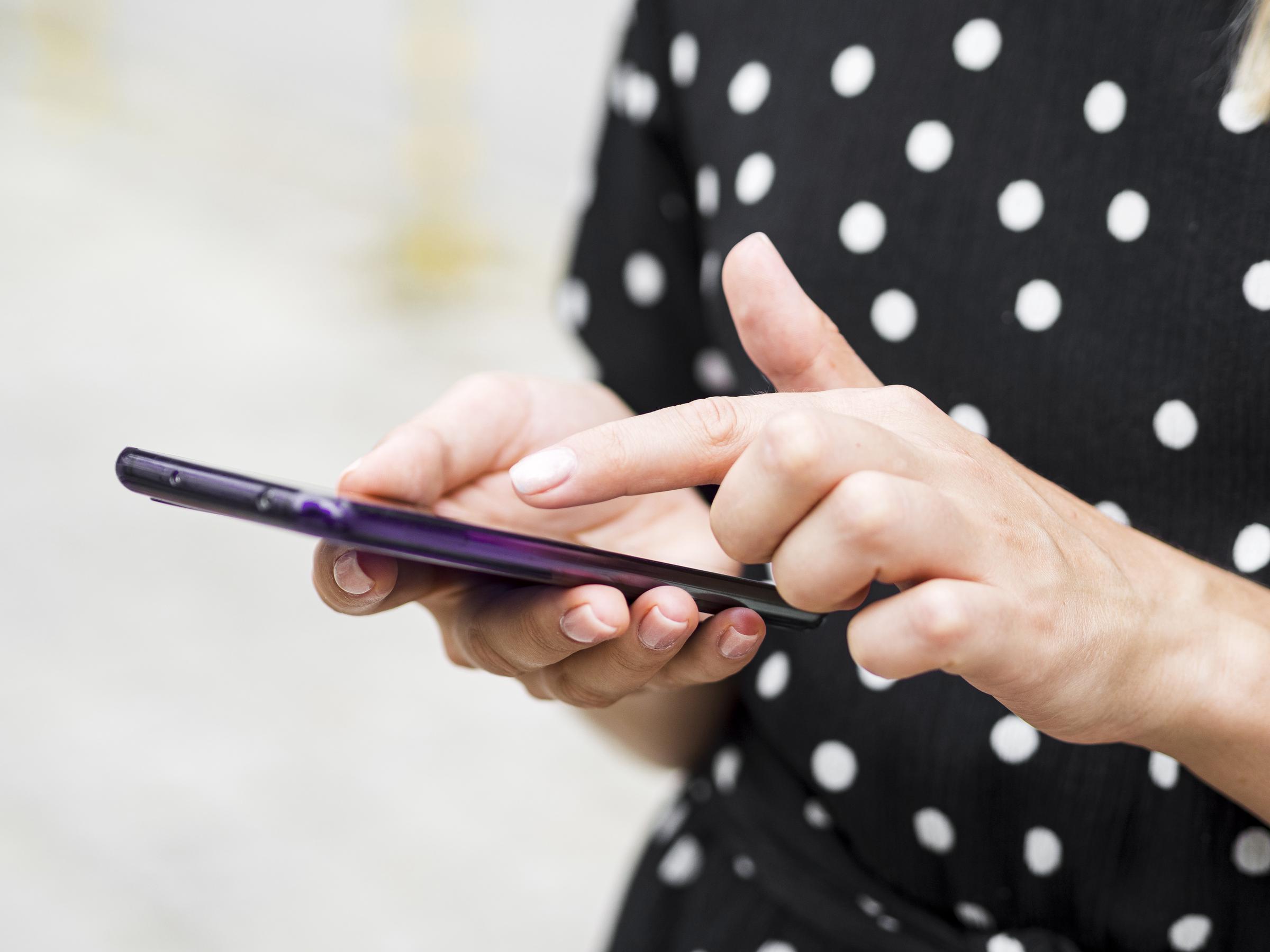 Une jeune femme lisant les textes sur son téléphone | Source : Freepik