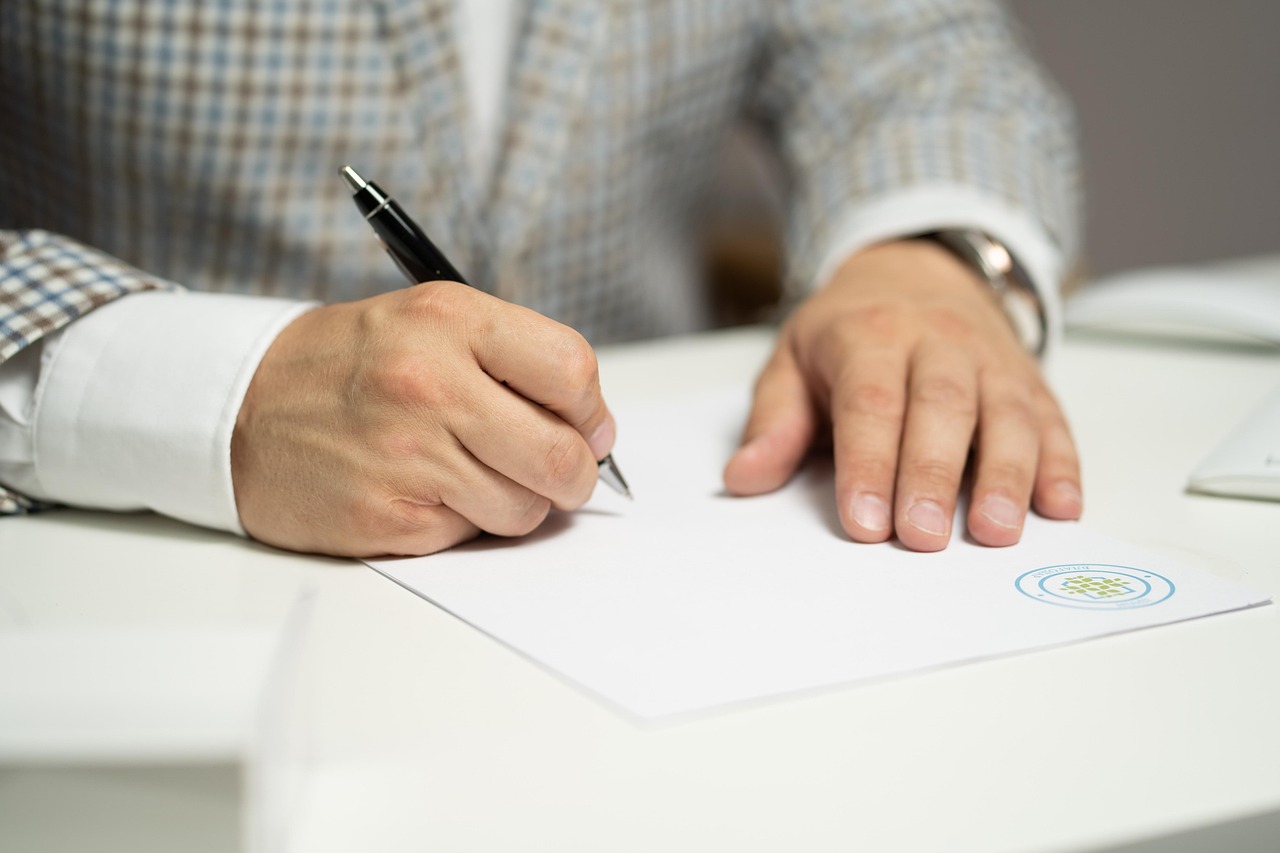 Un homme signant un document | Source : Pixabay