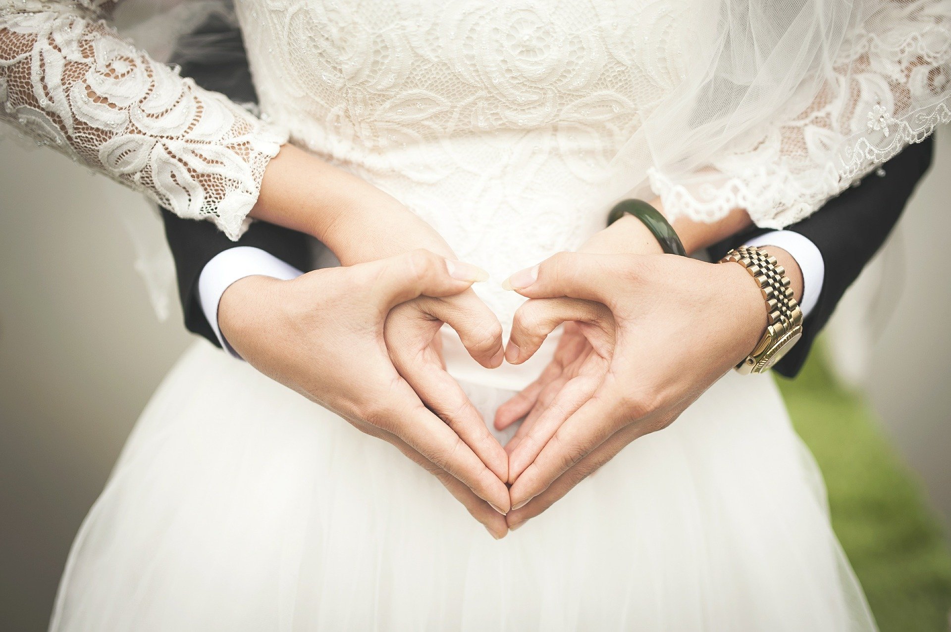 Une mariée et un marié font un signe du cœur avec leurs mains. | Source : Pixabay.com