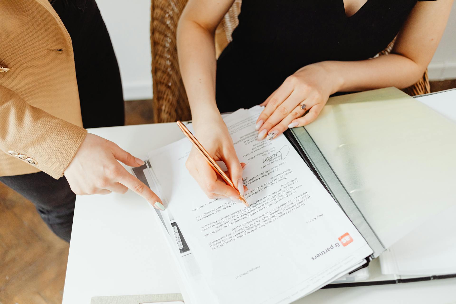 Une femme signant des documents | Source : Pexels