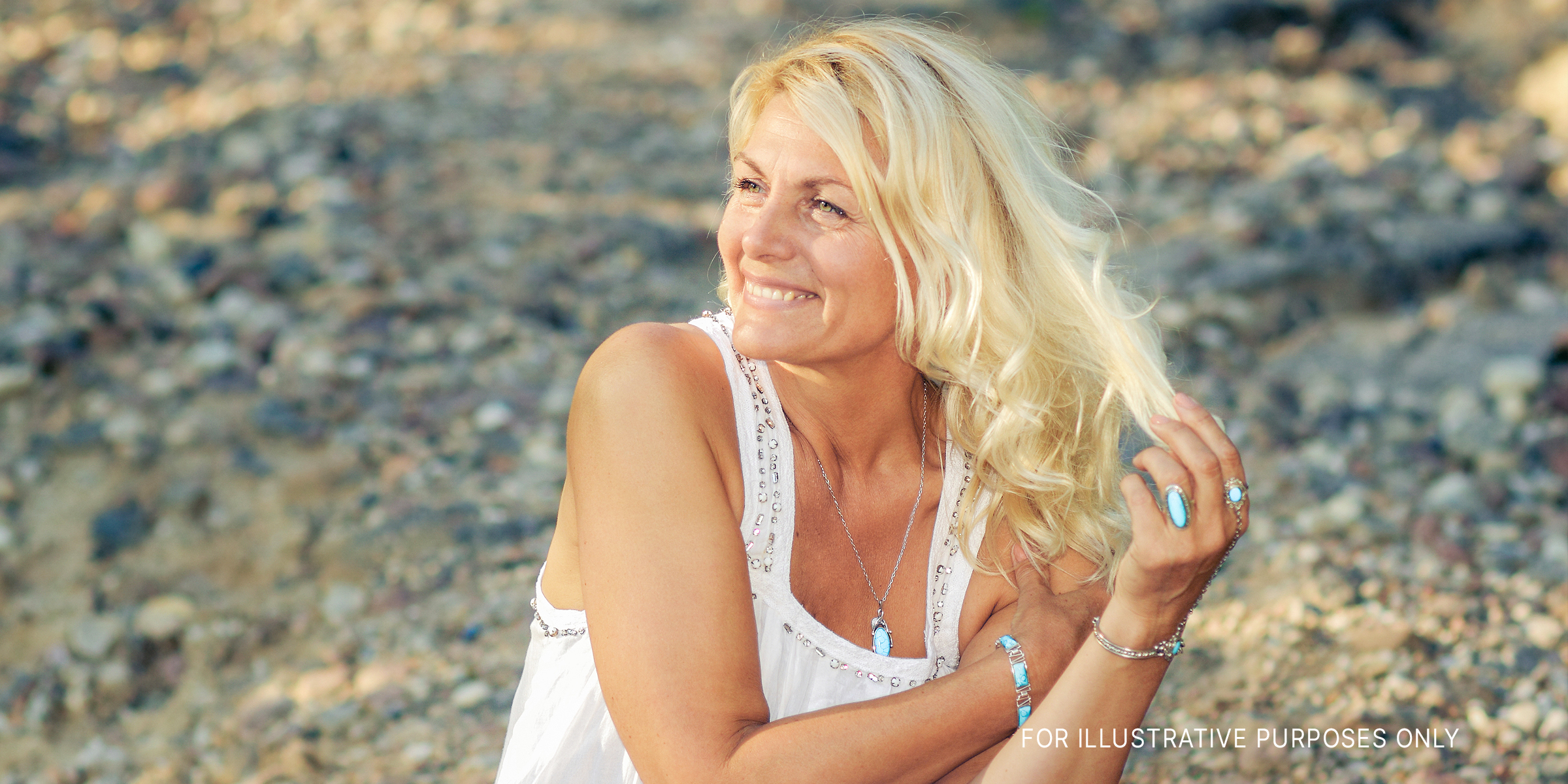 Une femme souriante vêtue d'une robe blanche | Source : Shutterstock