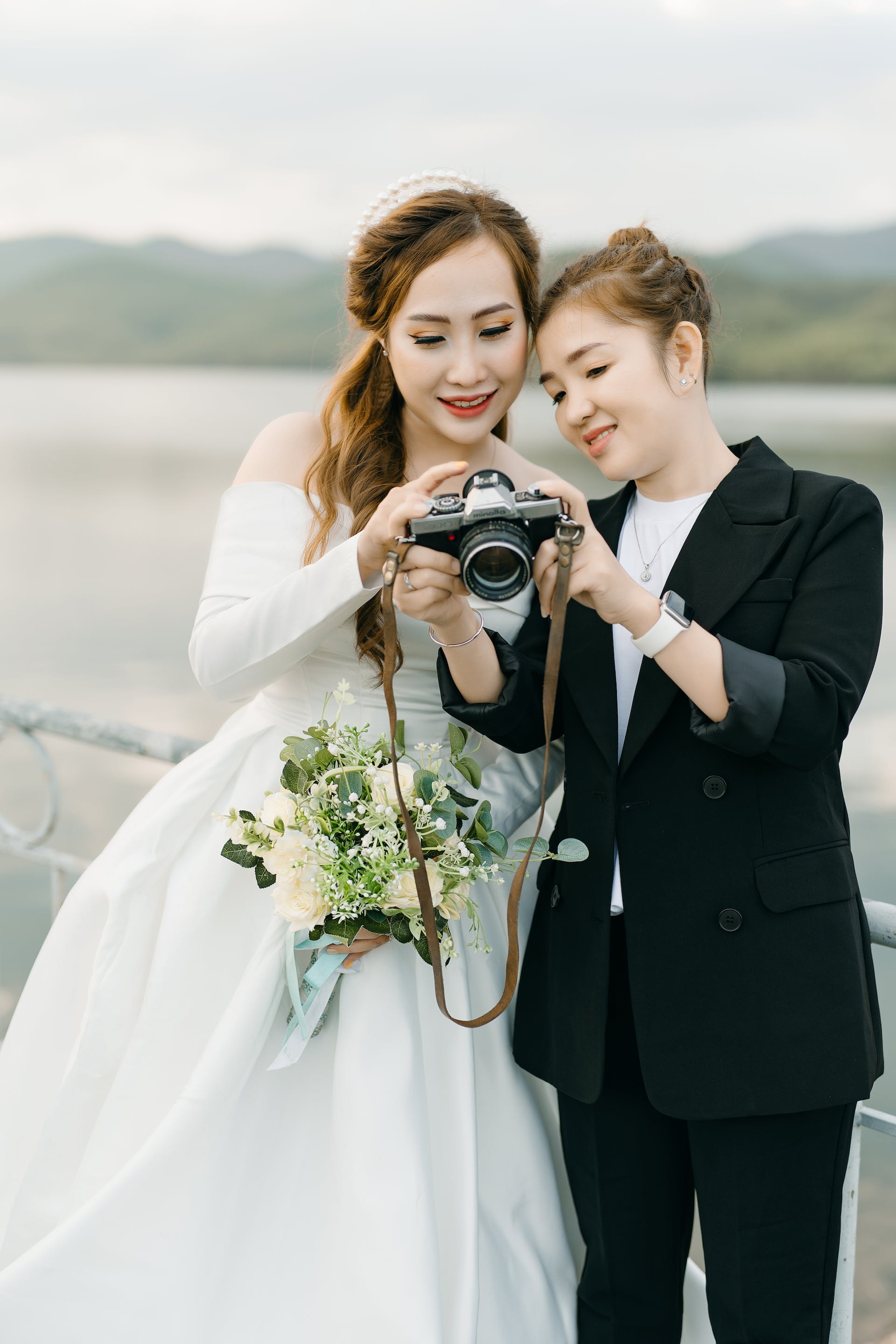 Un fotógrafo enseñando fotos a una novia | Fuente: Pexels
