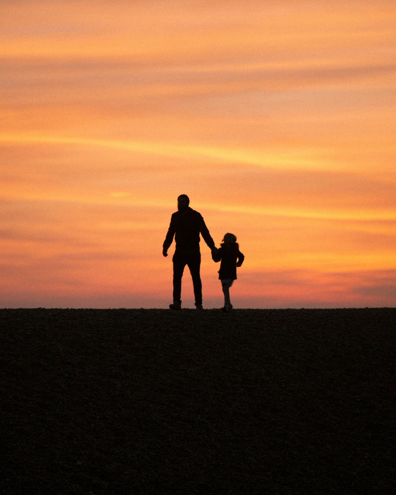 Silhouette d'un homme marchant avec sa petite fille | Source : Pexels