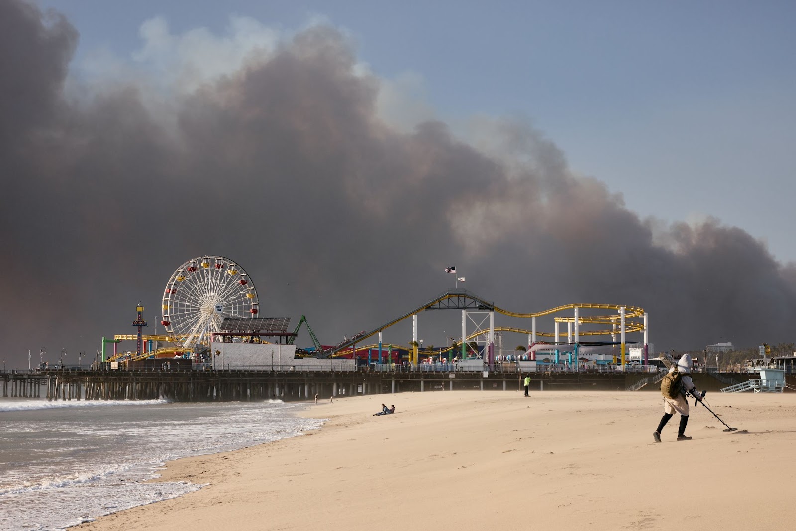 Une photo de la jetée de Santa Monica avec l'incendie des Palisades brûlant au loin, le 7 janvier 2025. | Source : Getty Images