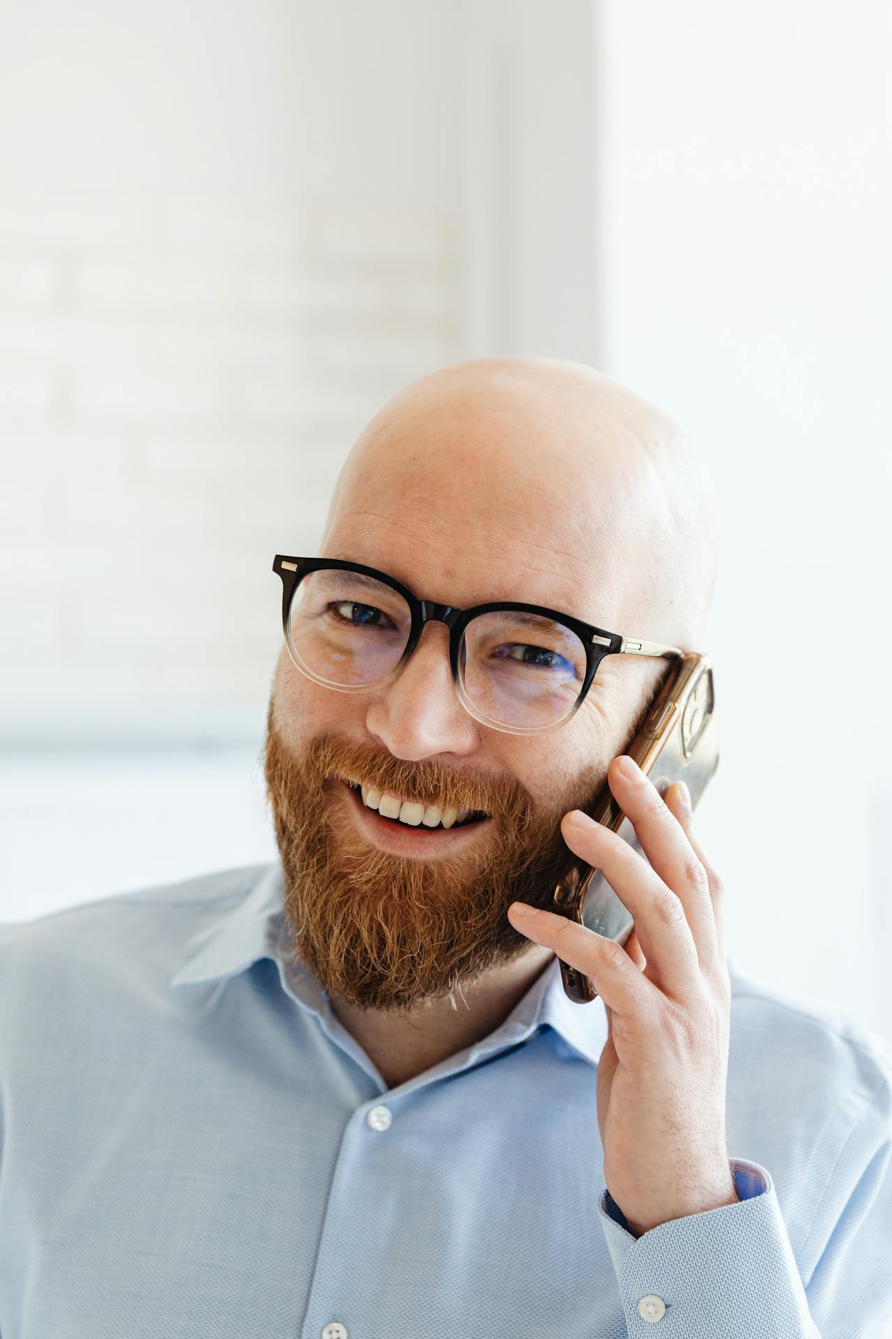 Un homme souriant qui parle au téléphone | Source : Pexels