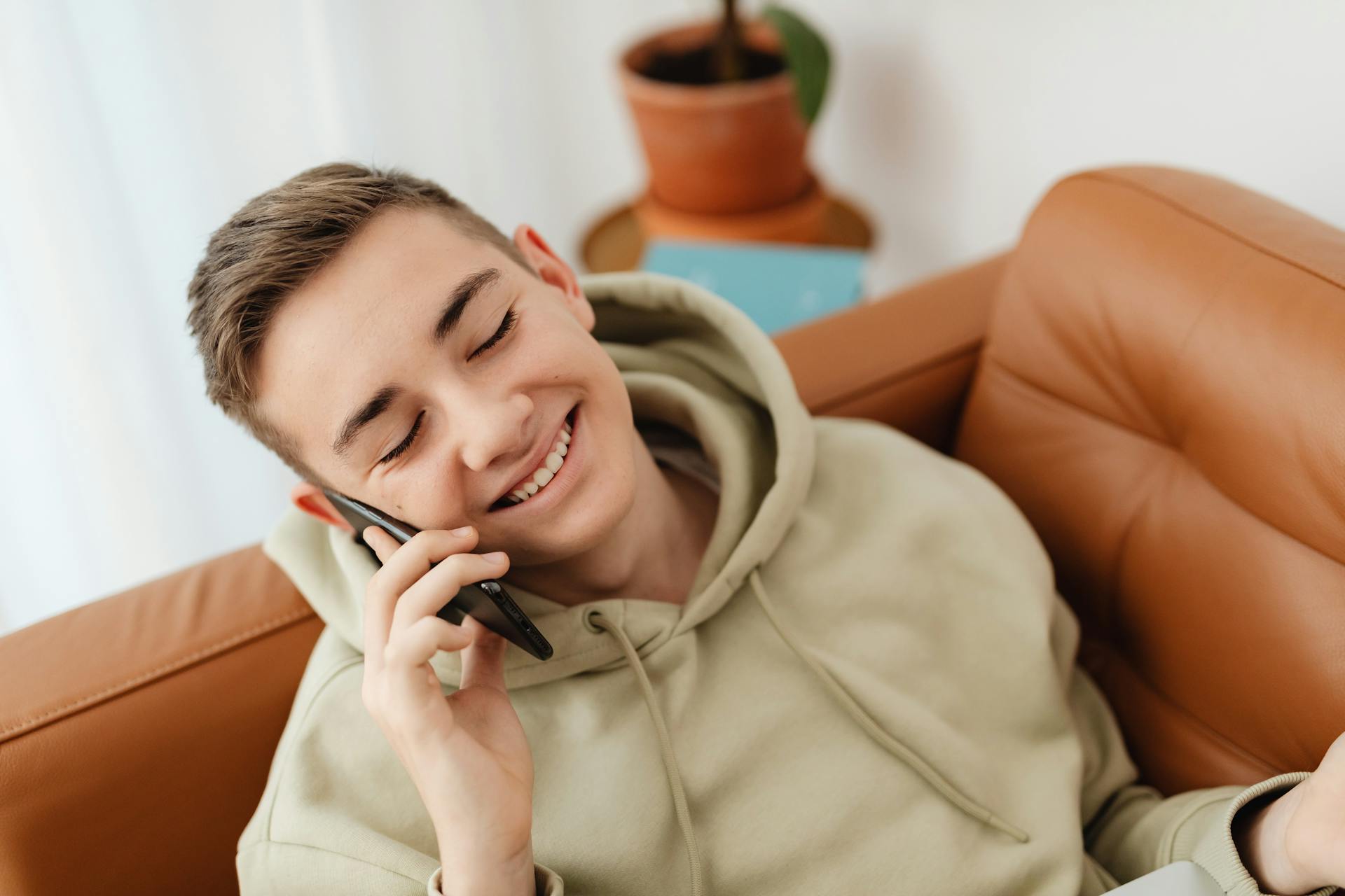 Un adolescent ravi de parler au téléphone | Source : Pexels