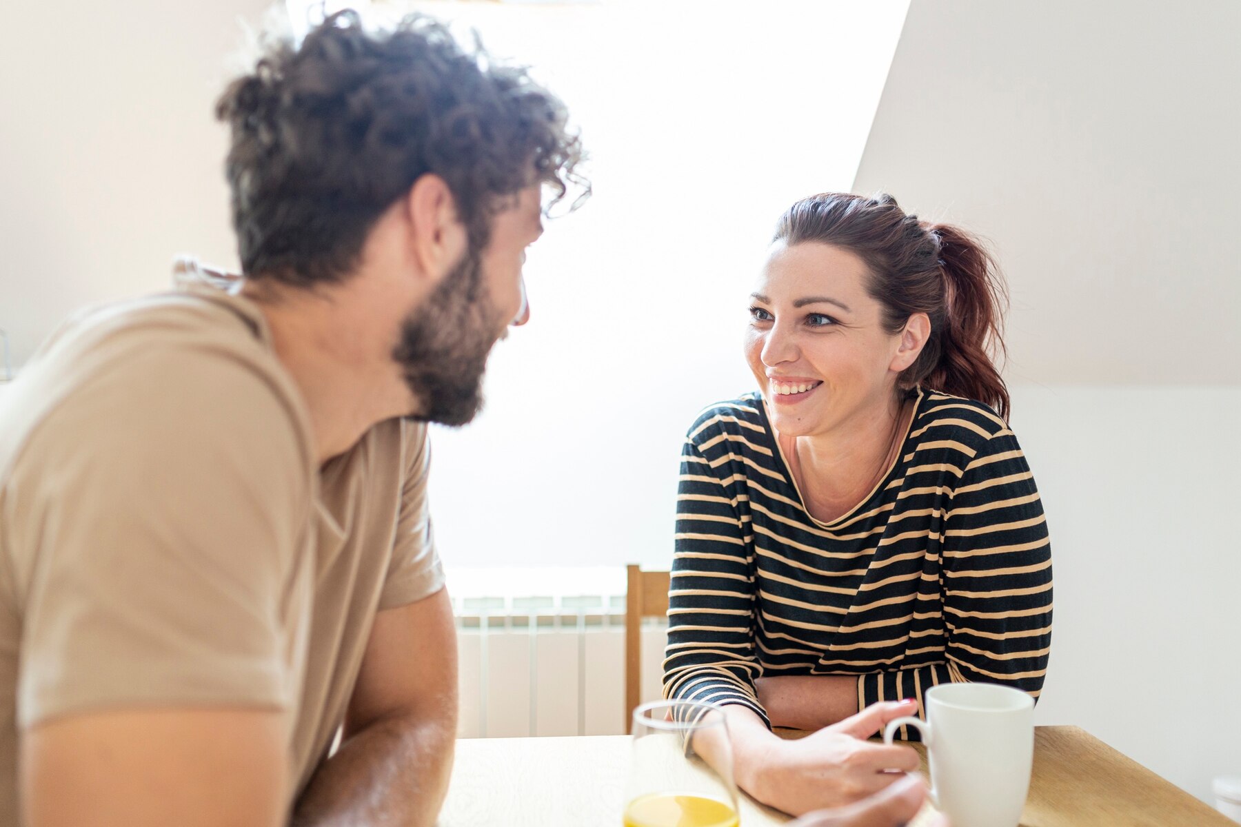 Un couple heureux qui discute autour d'un café | Source : Freepik