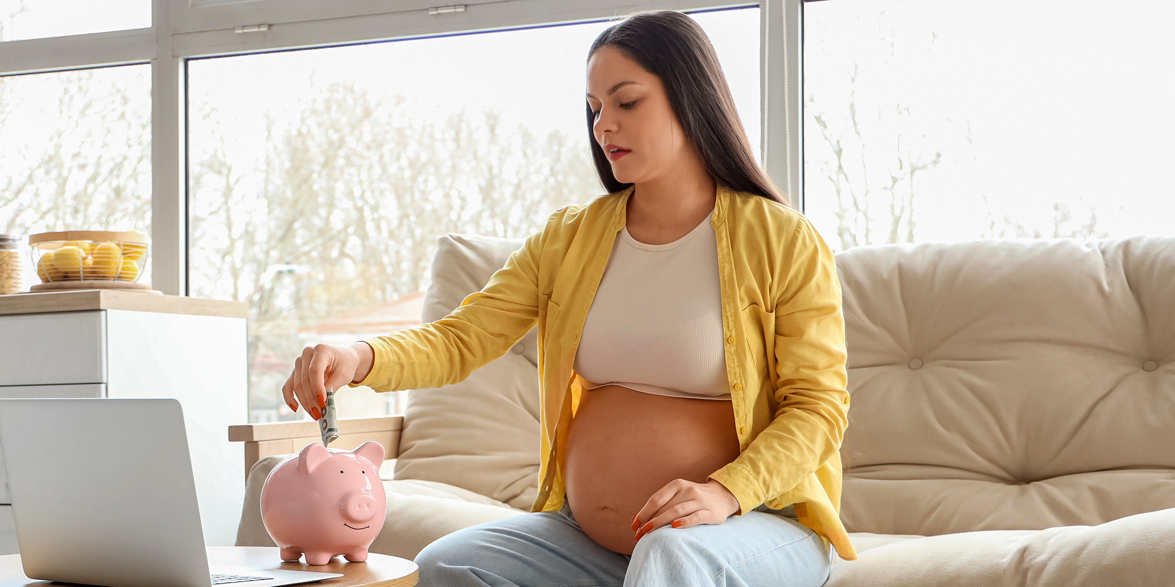 Une femme enceinte économisant de l'argent dans une tirelire | Source : Shutterstock