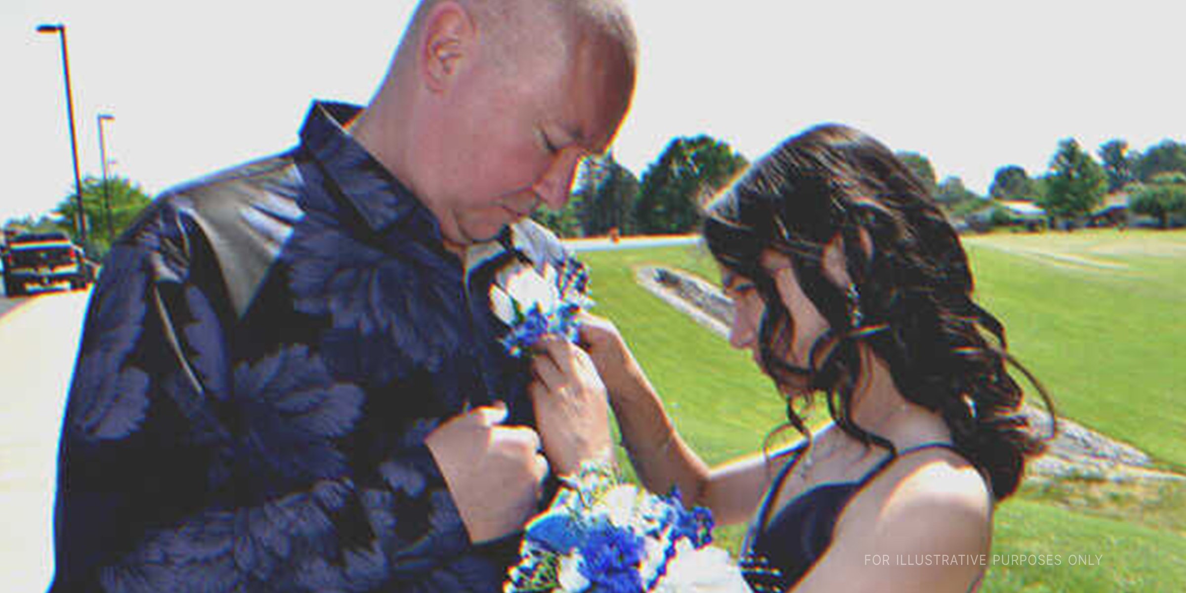 Une jeune fille qui épingle des fleurs sur la chemise d'un homme plus âgé | Source : Shutterstock