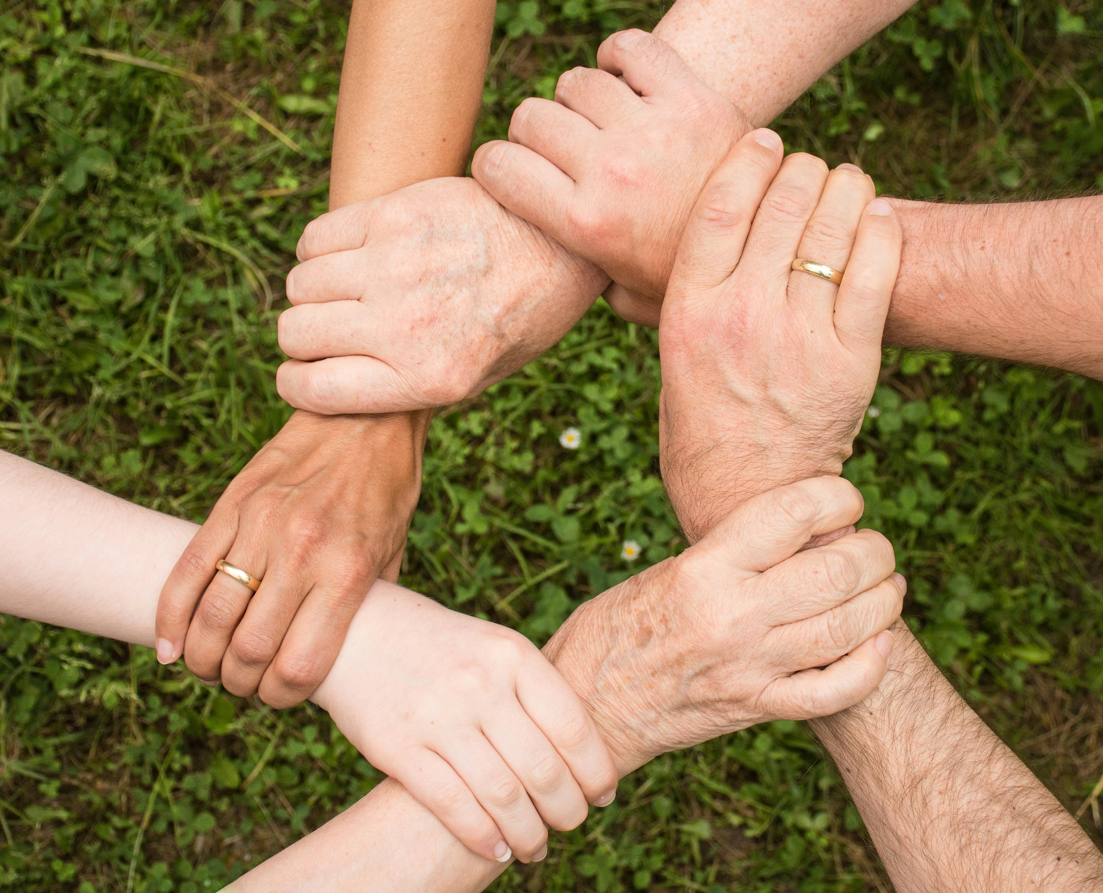 Des personnes se tiennent par le bras | Source : Pexels