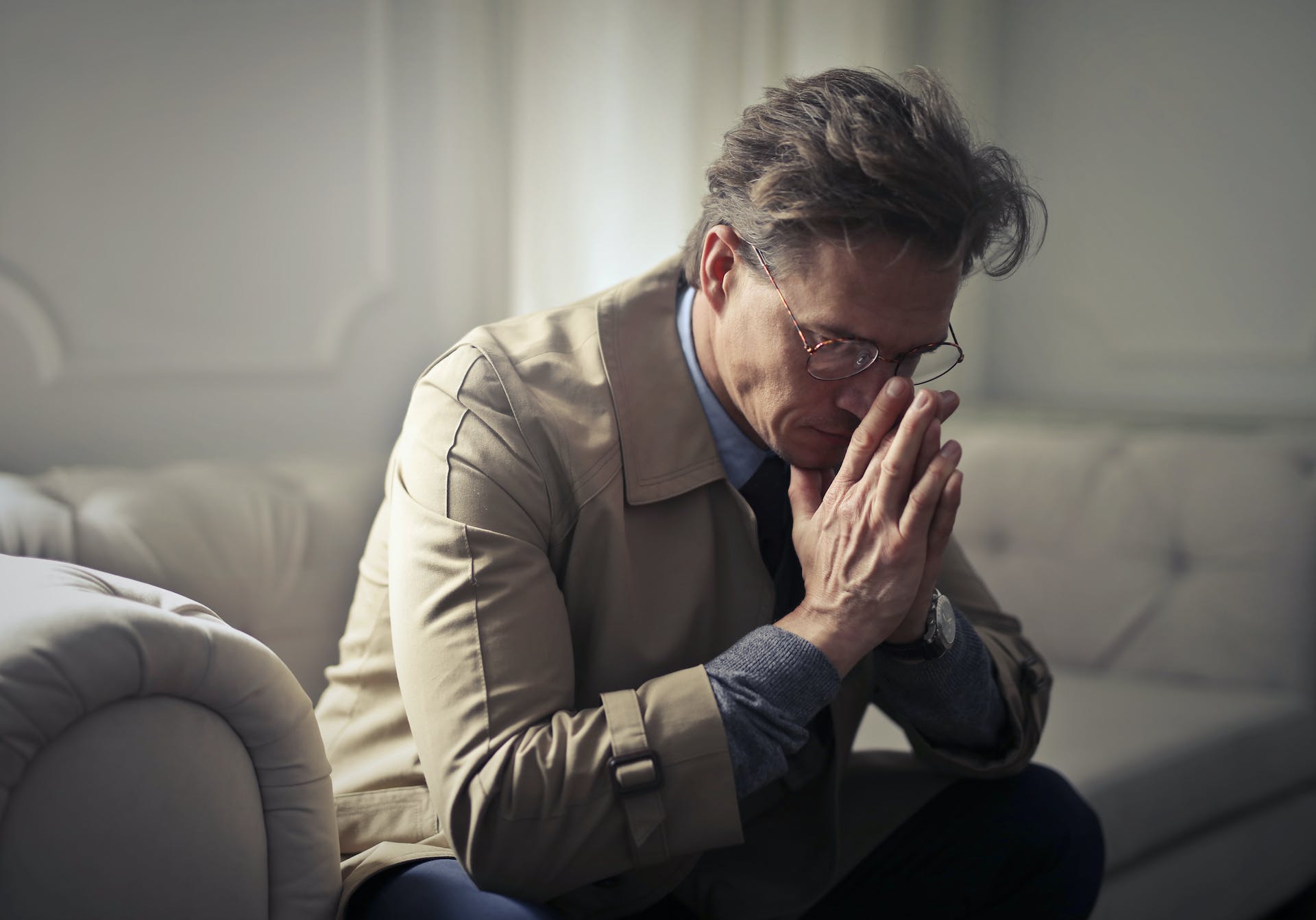 Un homme stressé assis sur un canapé | Source : Pexels