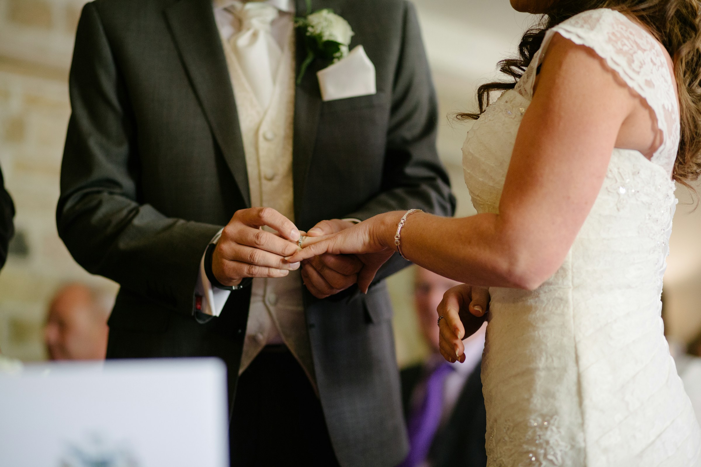 Gros plan d'un marié plaçant une alliance au doigt de sa promise | Source : Unsplash