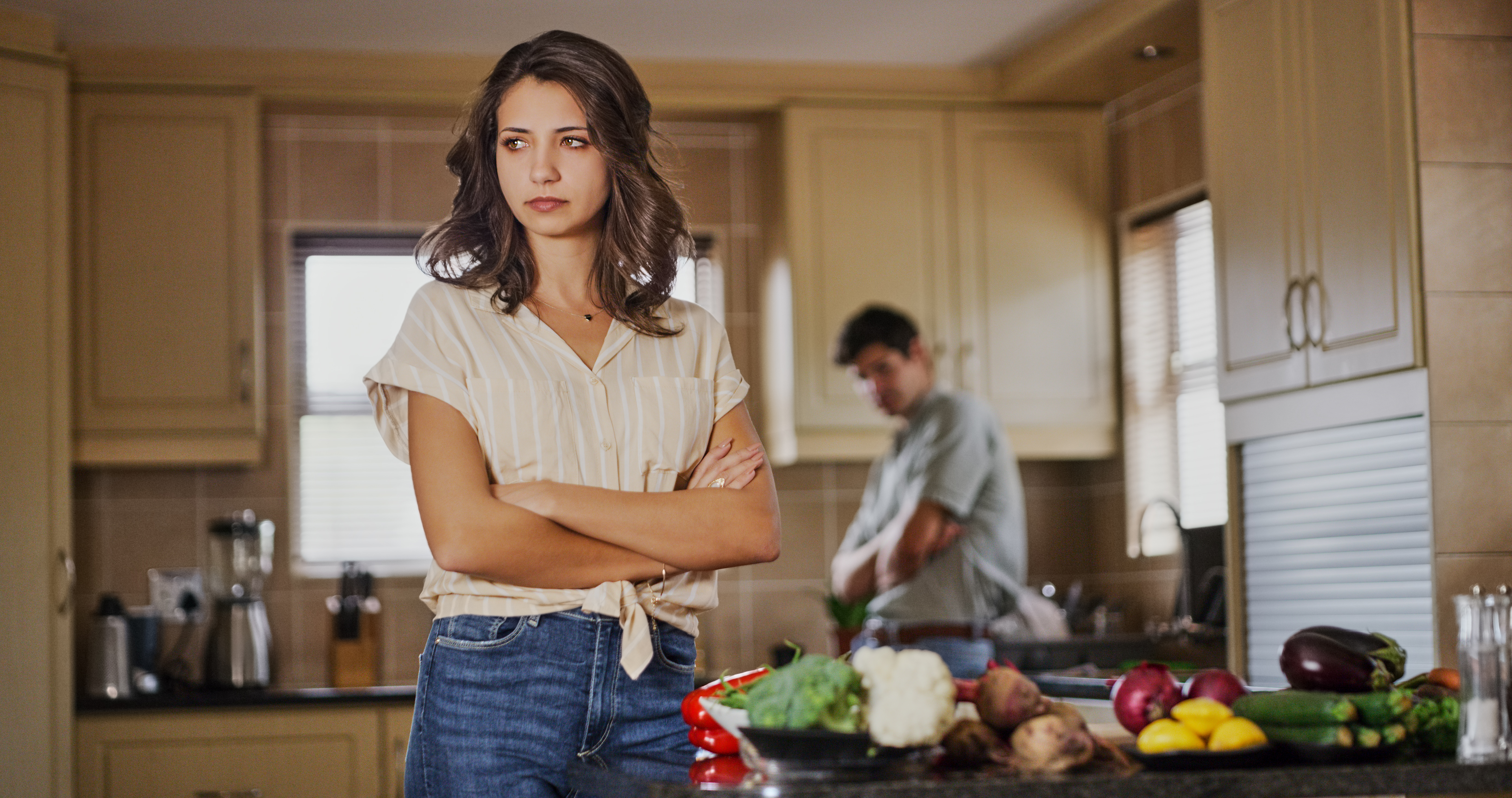 Une femme qui s'énerve contre son mari qui se tient à l'arrière-plan | Source : Getty Images