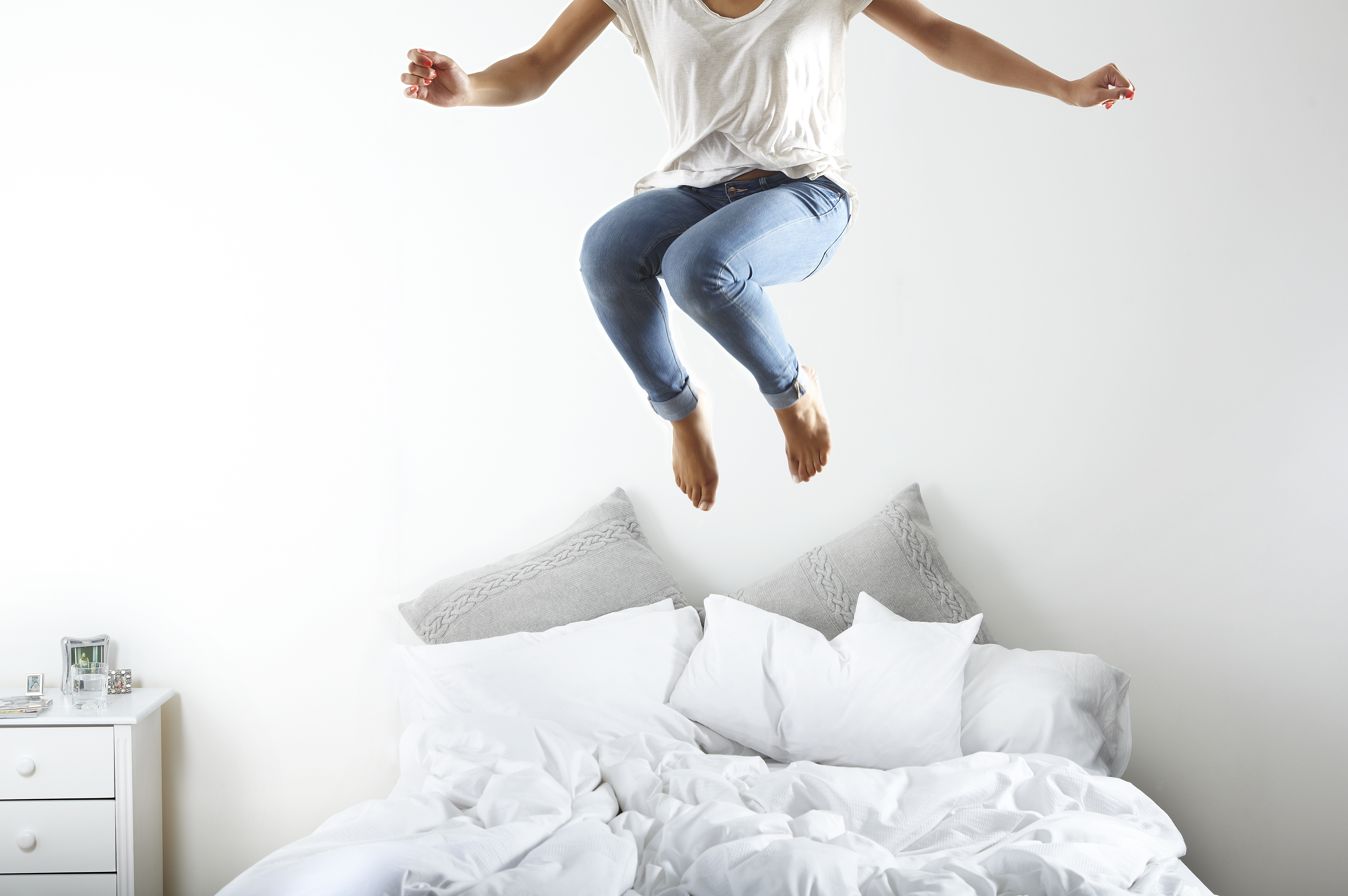 Portrait d'une femme sautant sur le lit | Source : Getty Images
