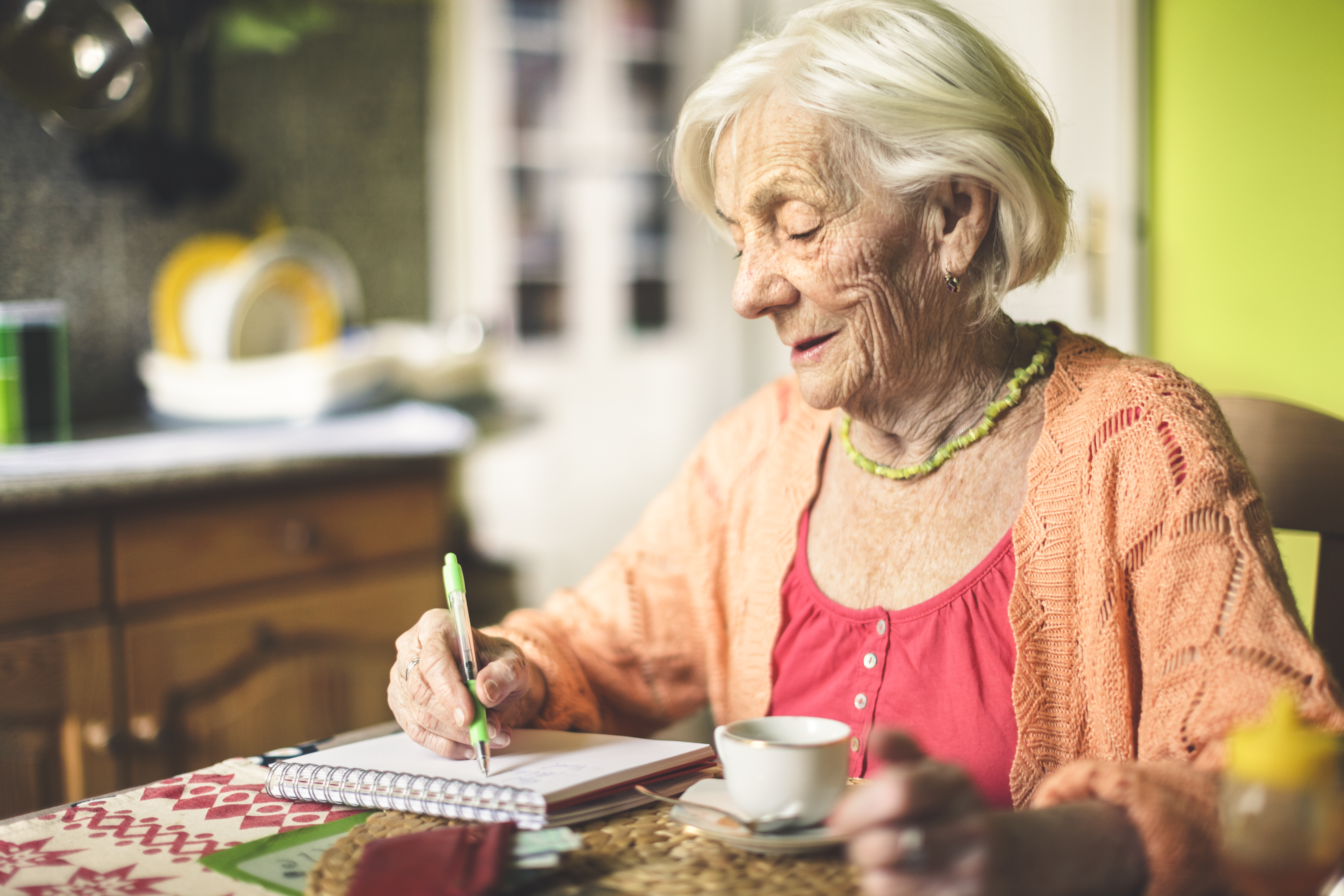 Une femme âgée calculant ses finances dans sa cuisine | Source : Getty Images