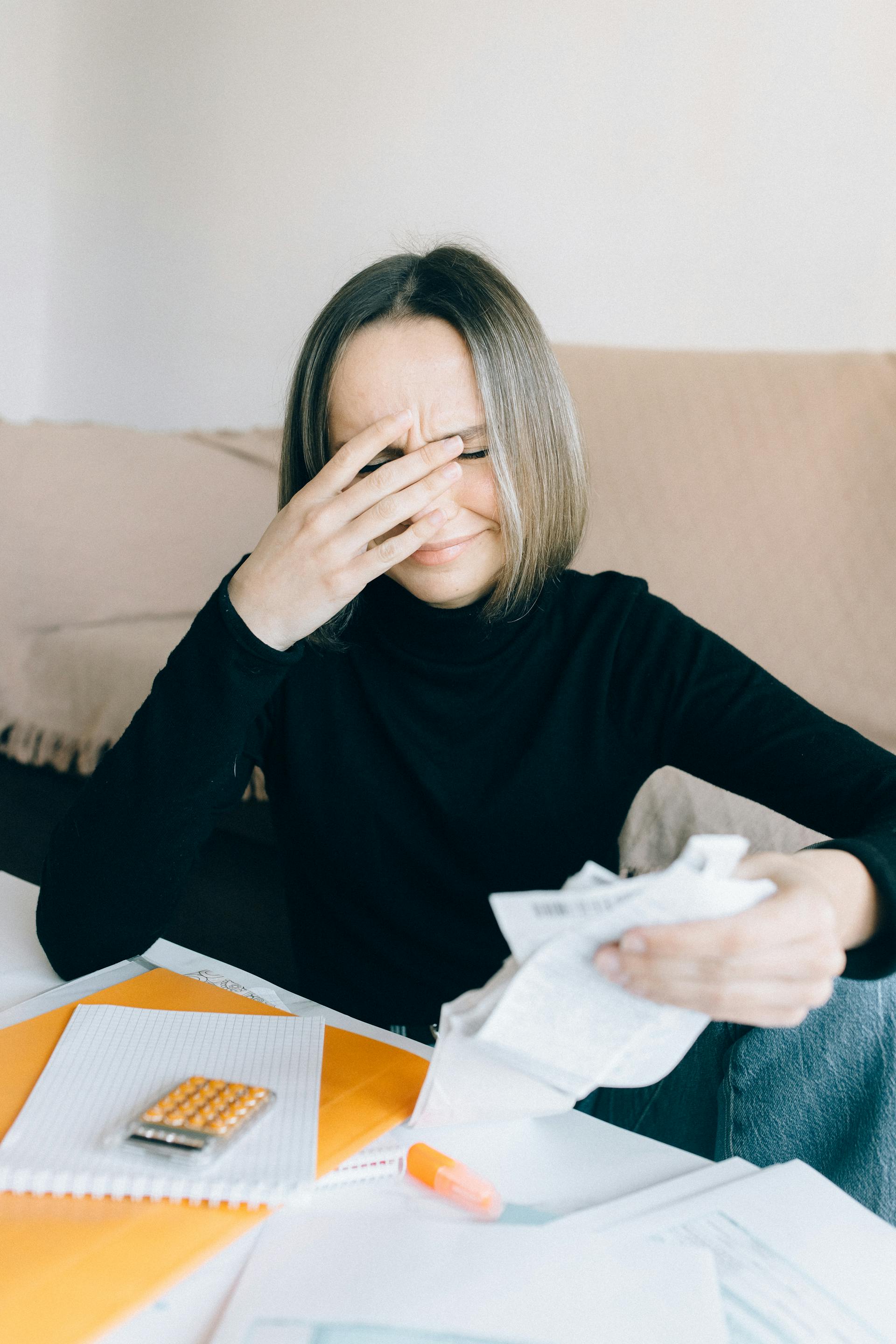 Une femme émotive tenant des reçus | Source : Pexels