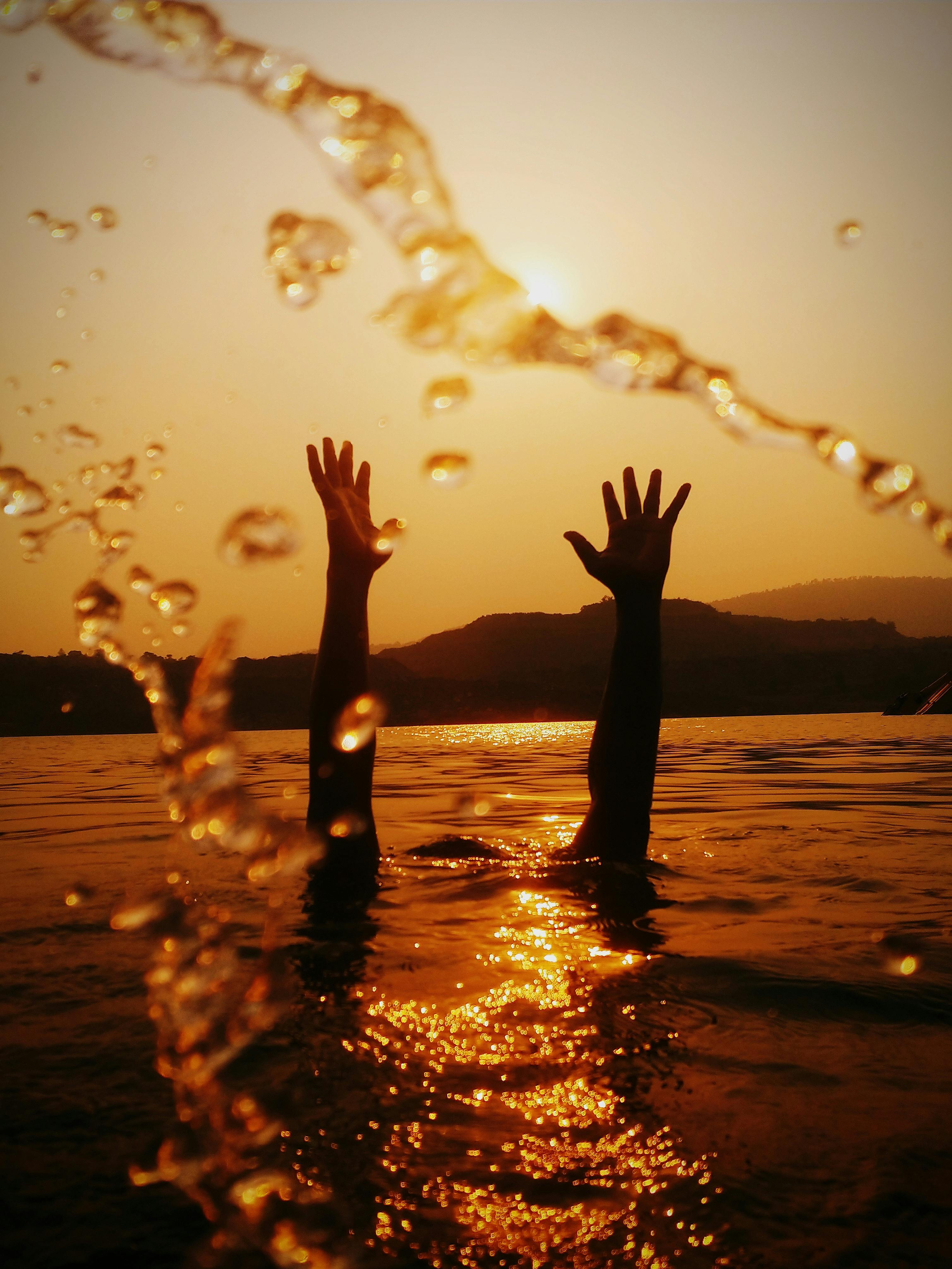 Les mains au-dessus de la surface de l'eau | Source : Pexels