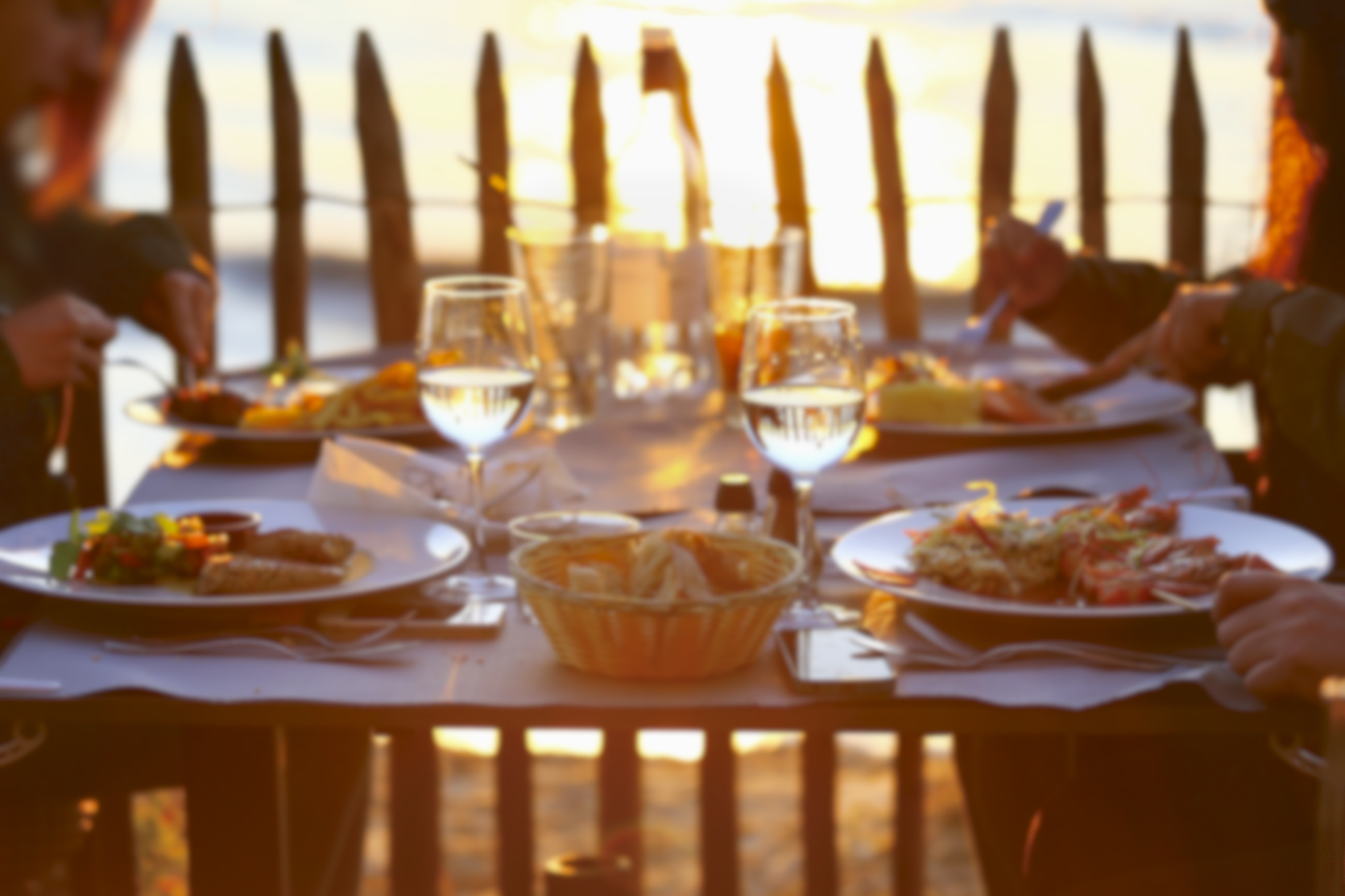 Des gens profitent d'un dîner au coucher du soleil | Source : Shutterstock