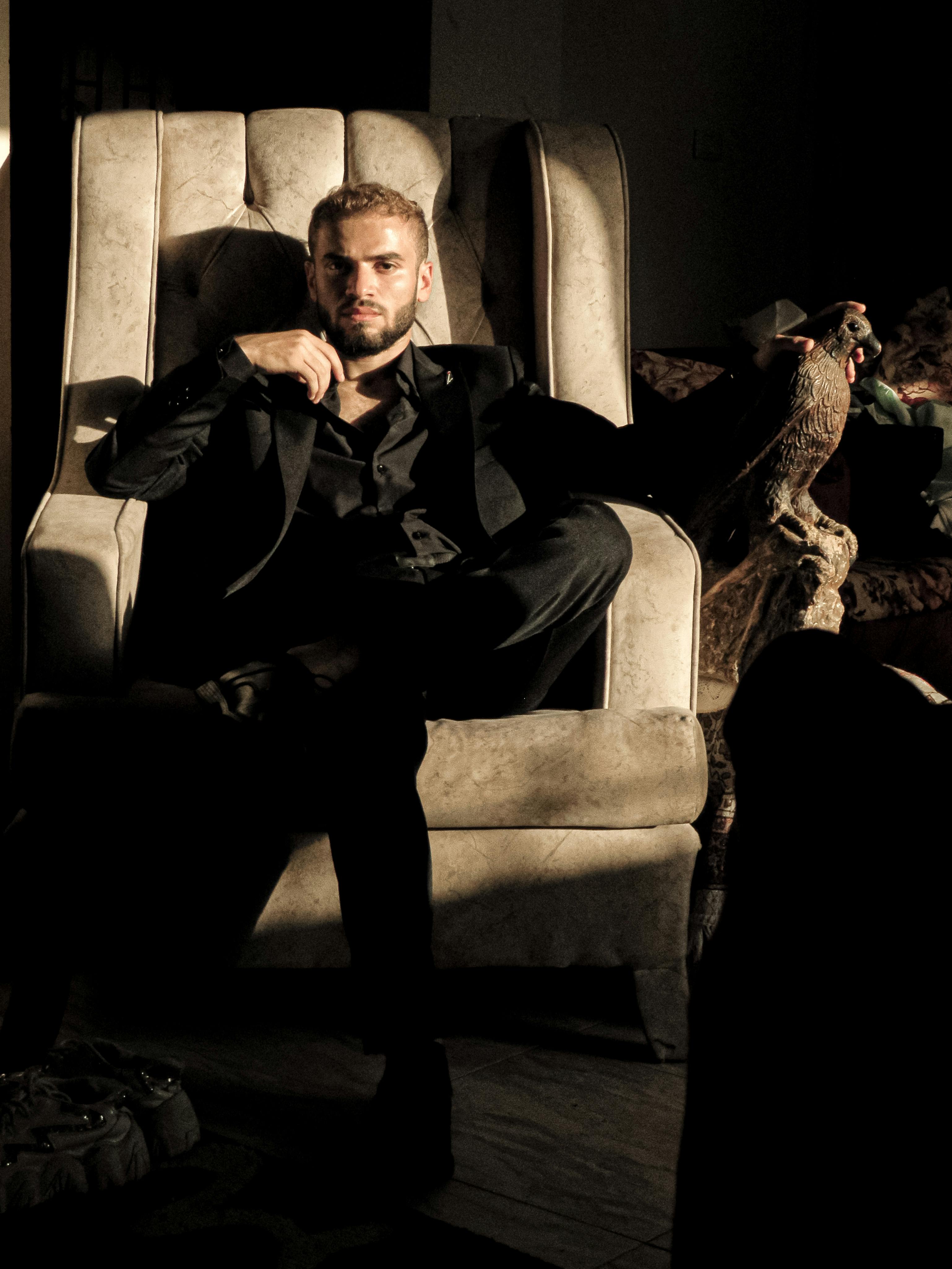 Un homme contemplatif assis dans un fauteuil | Source : Pexels
