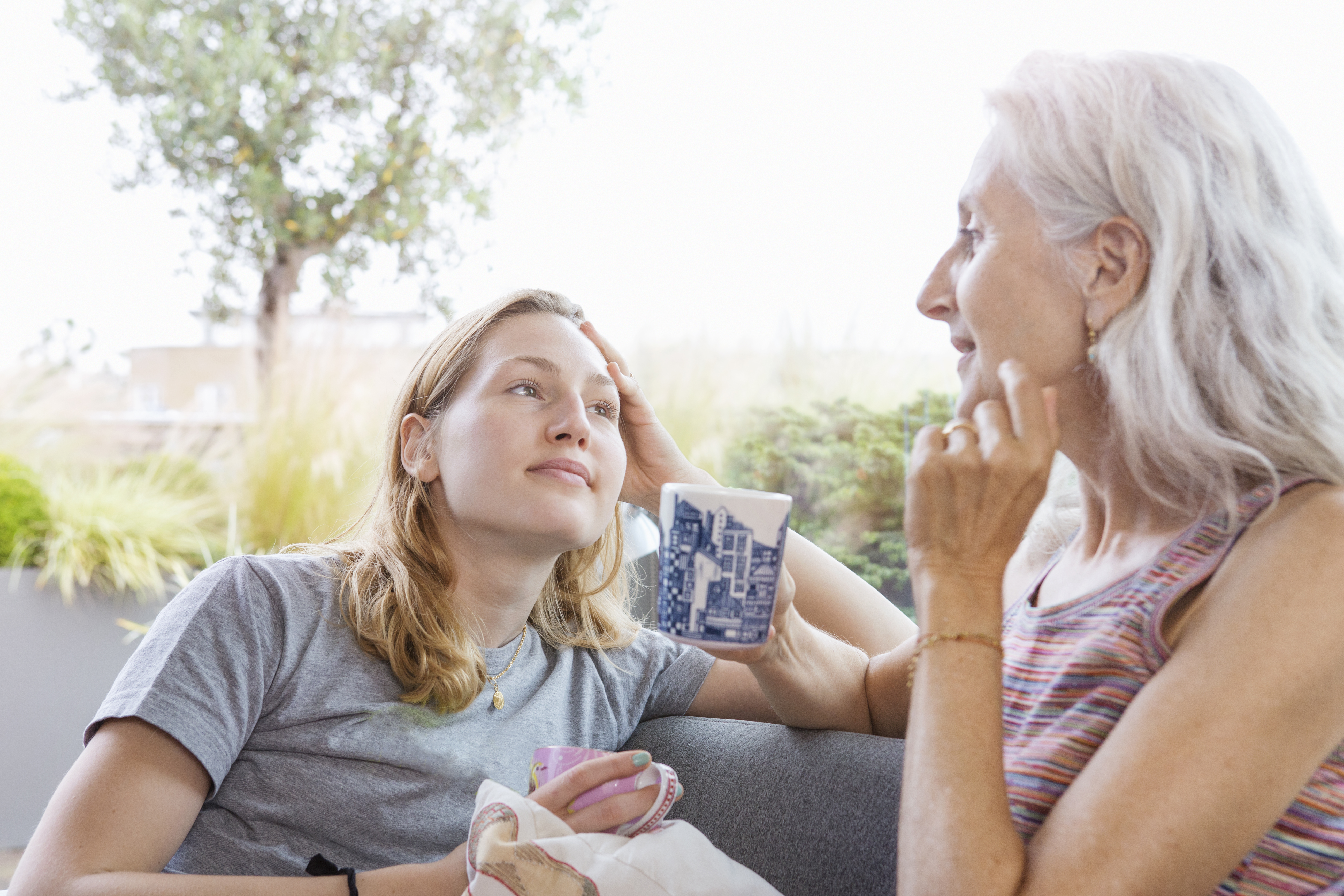 Une femme âgée discute avec sa fille sur le canapé | Source : Getty Images