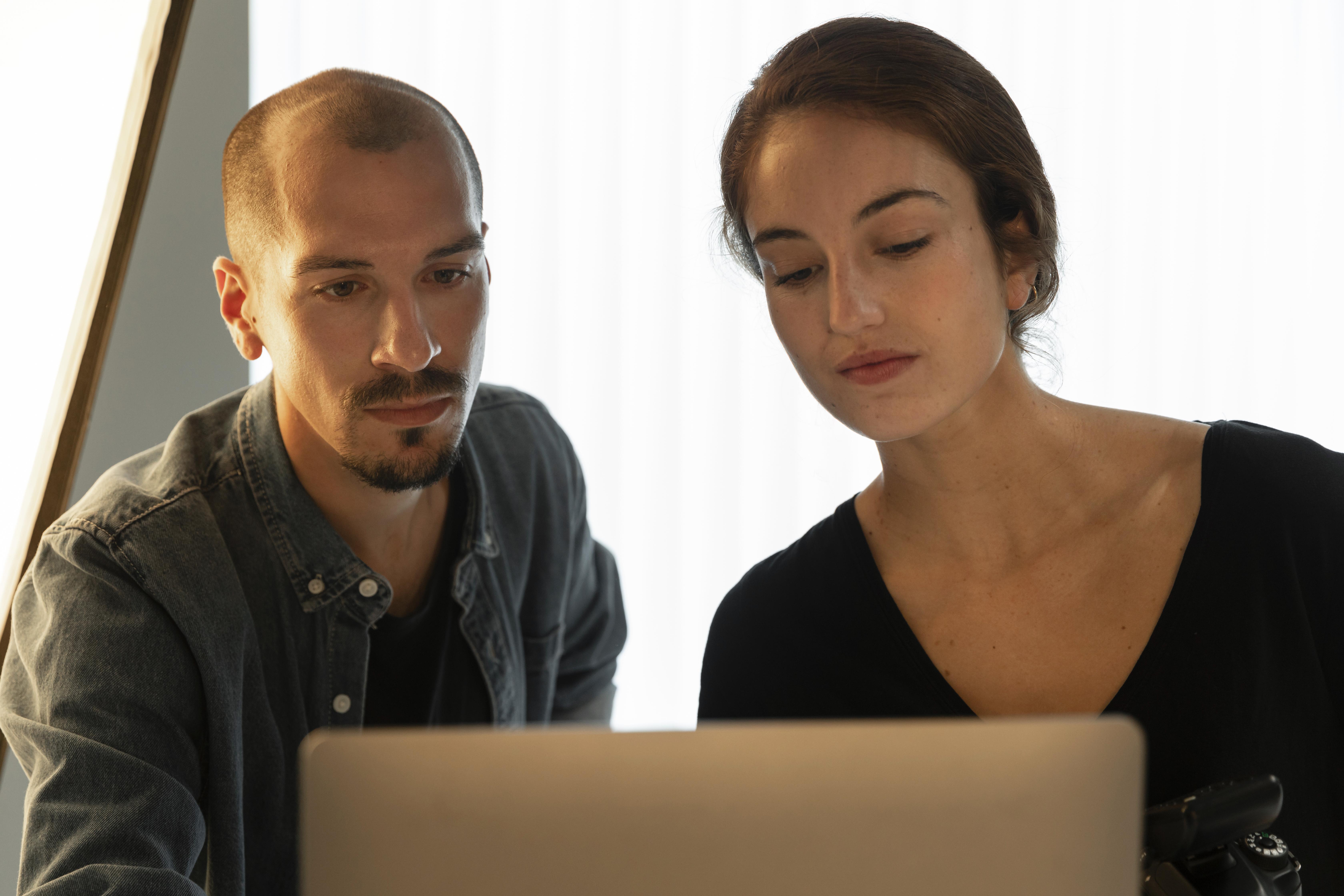 Une photo d'un homme et d'une femme regardant un ordinateur portable | Source : Freepik