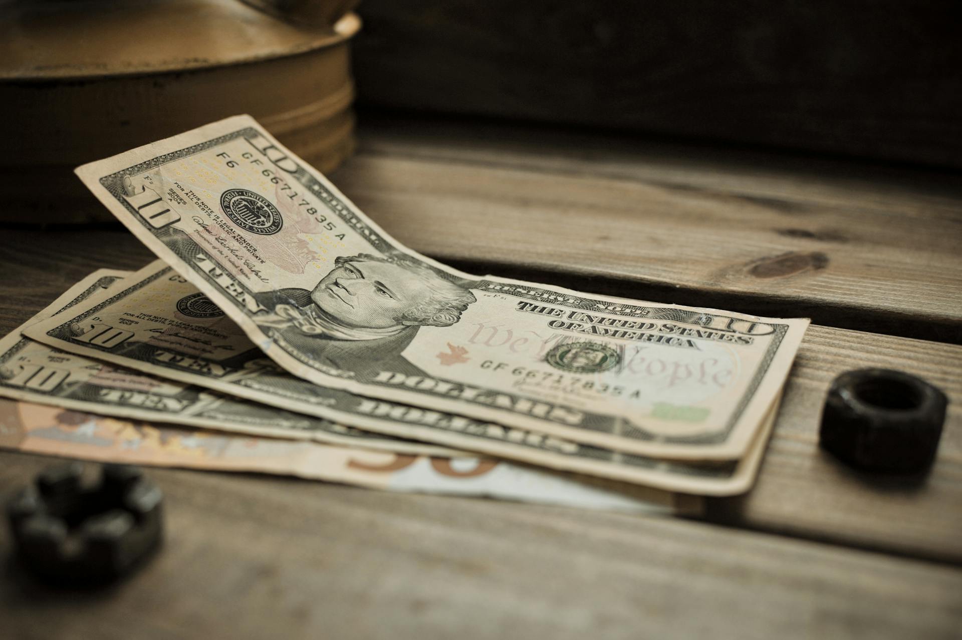 10 US dollar bills lying on a wooden surface | Source: Pexels