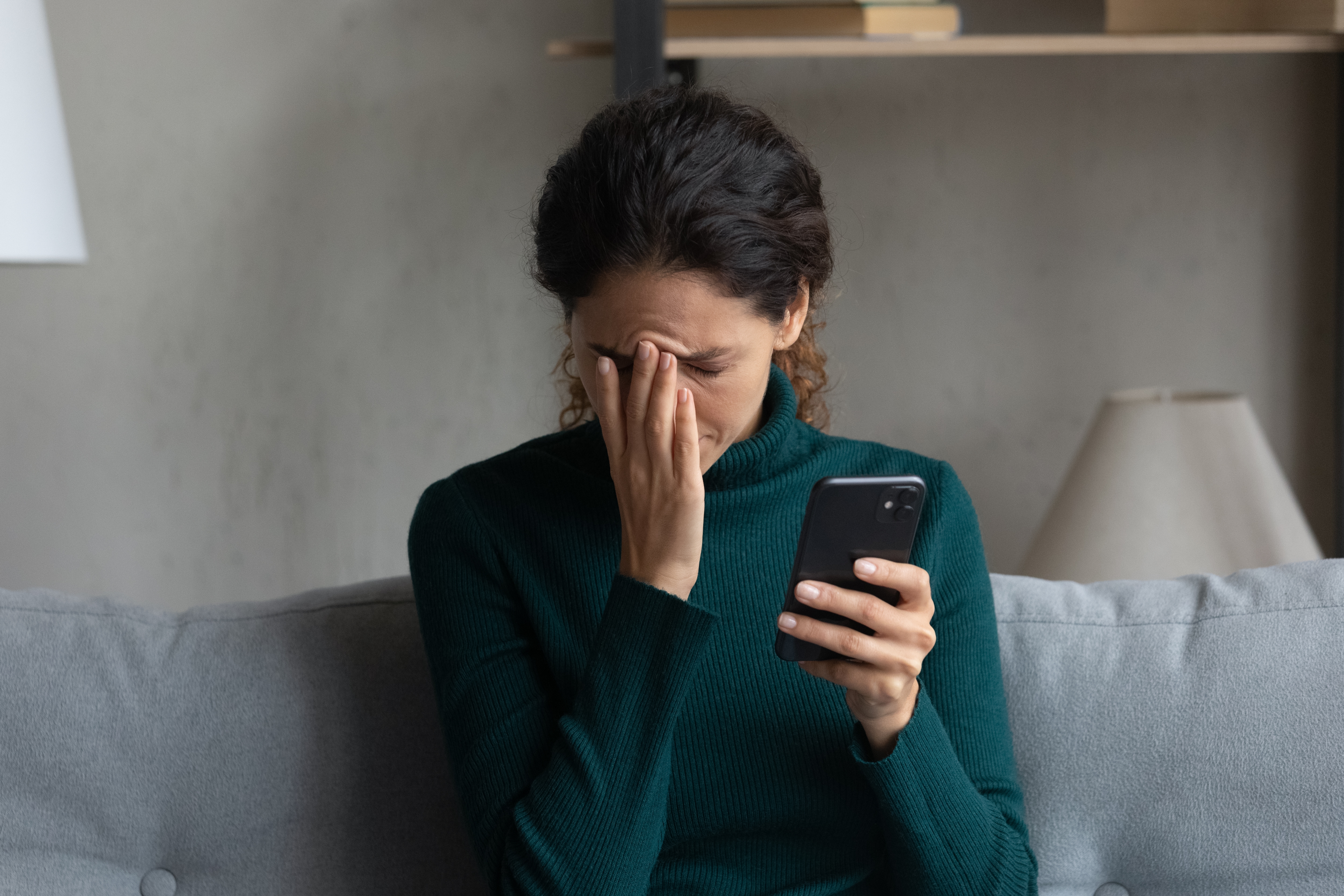 Une femme a l'air contrariée alors qu'elle tient son téléphone | Source : Shutterstock