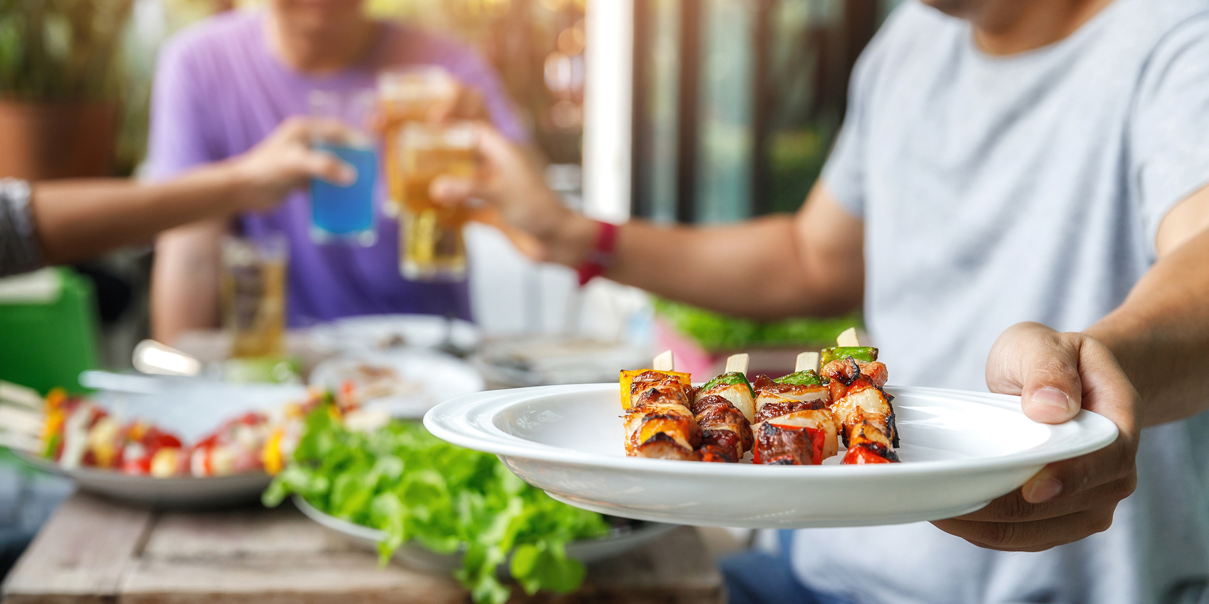 Un homme tenant une plaque de barbecue lors d'une fête | Source : Shutterstock
