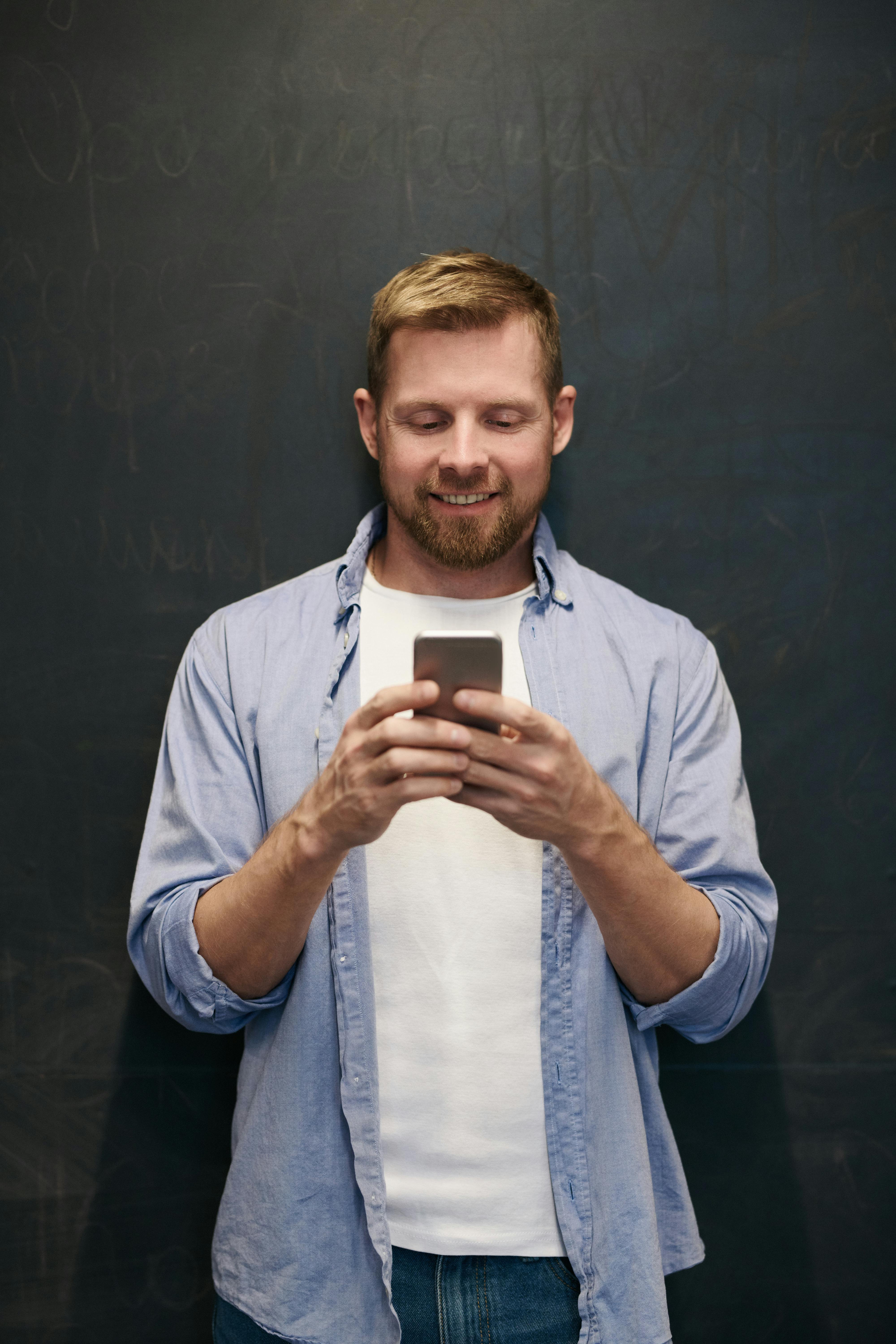 Un homme souriant qui décroche son téléphone | Source : Pexels