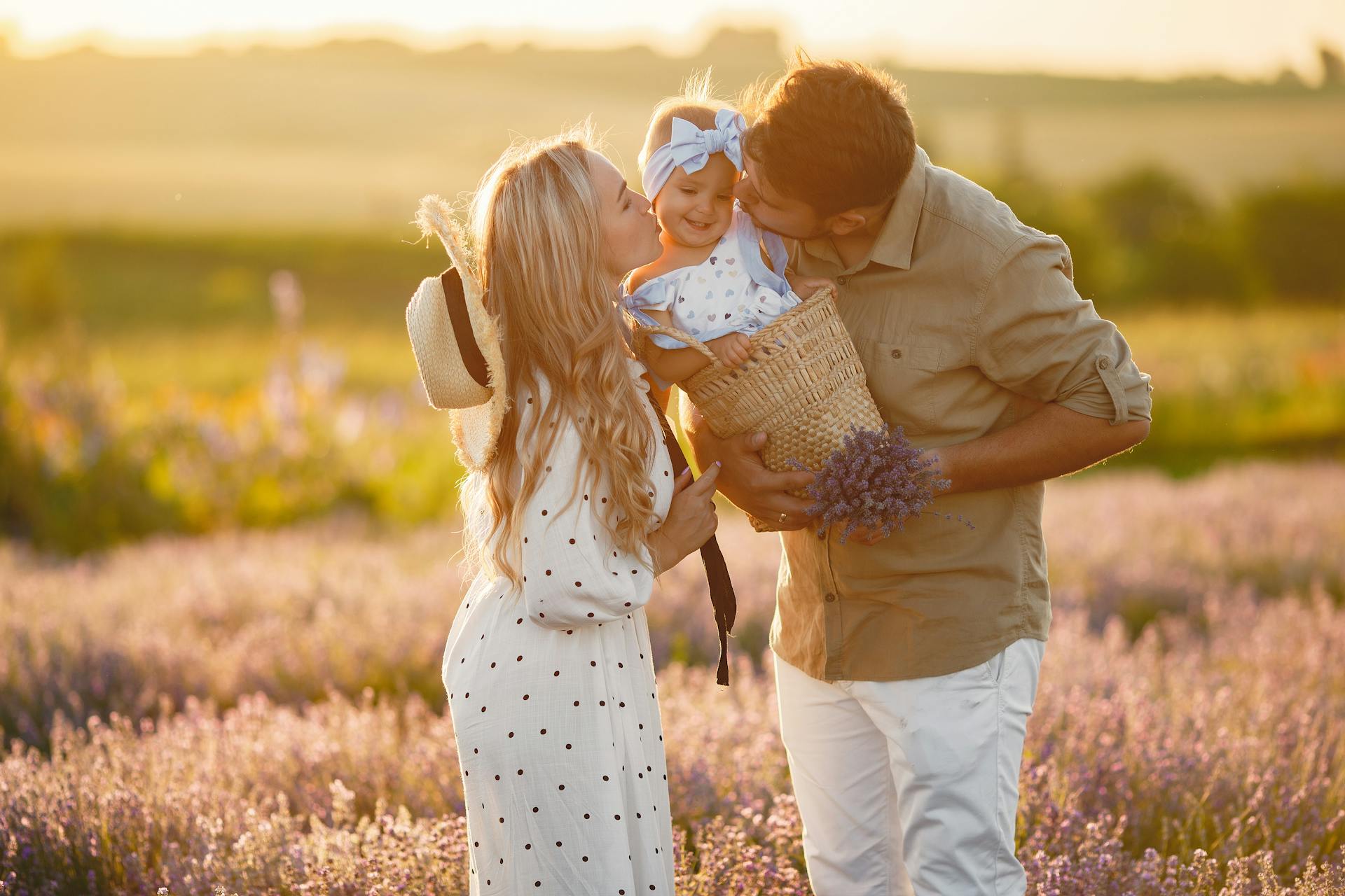 Un couple embrassant sa petite fille dans un champ de lavande | Source : Pexels