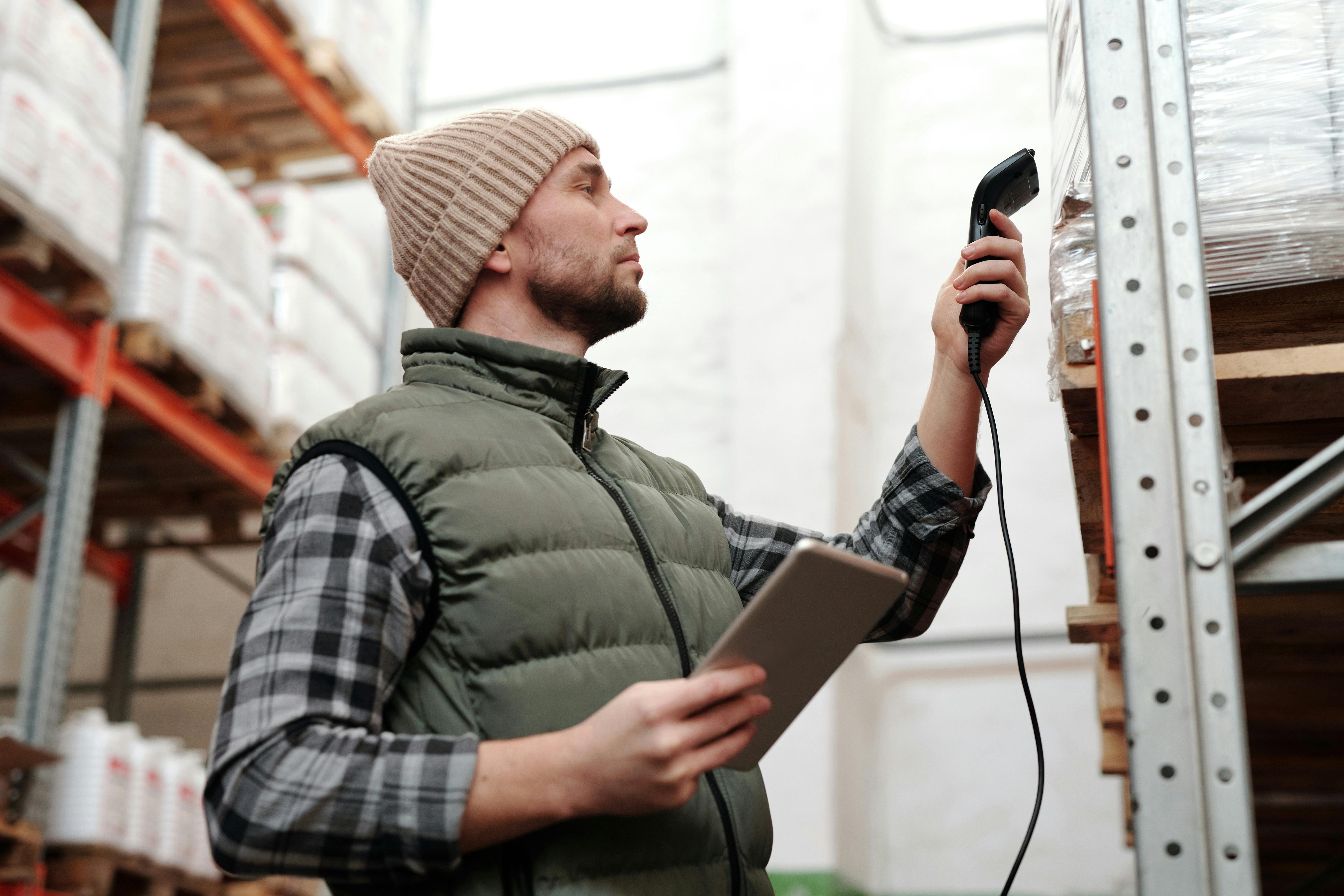 Un homme scanne des produits dans un entrepôt | Source : Pexels