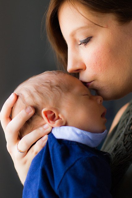 Une mère embrassant le front de son bébé. l Source: Flickr