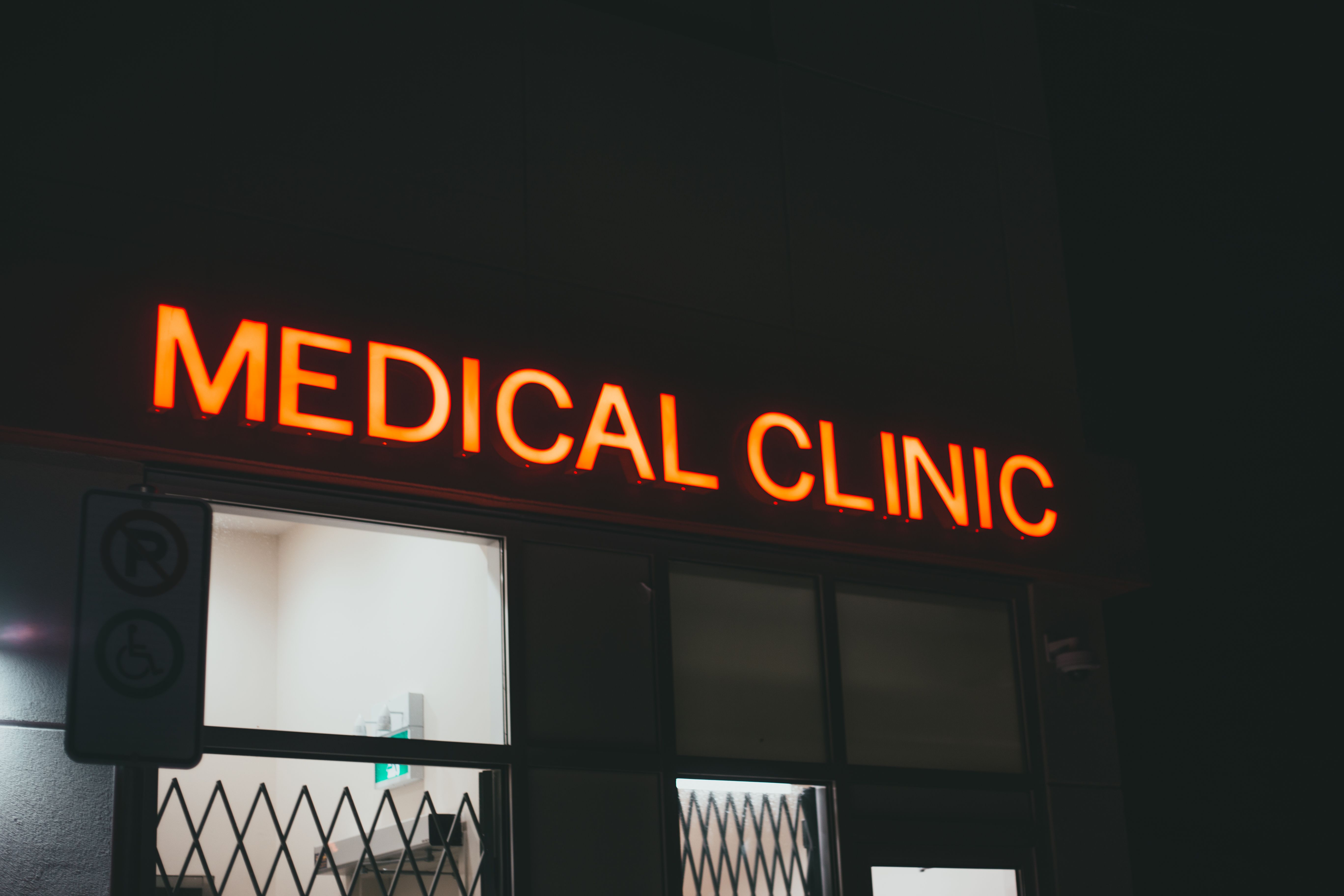 Une enseigne lumineuse au néon d'une clinique médicale la nuit, qui donne vie à la rue | Source : Pexels